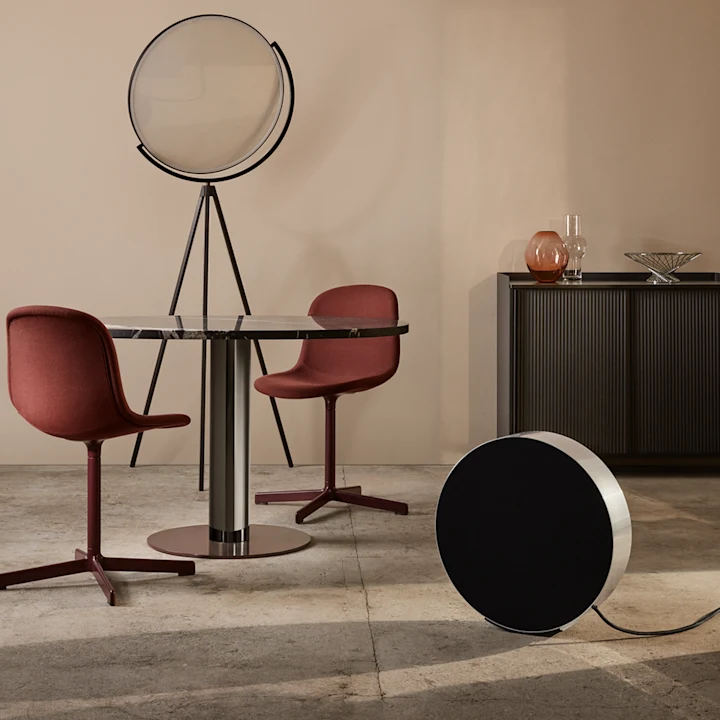 Beosound Edge speaker in natural aluminium in living room setting with table and chairs