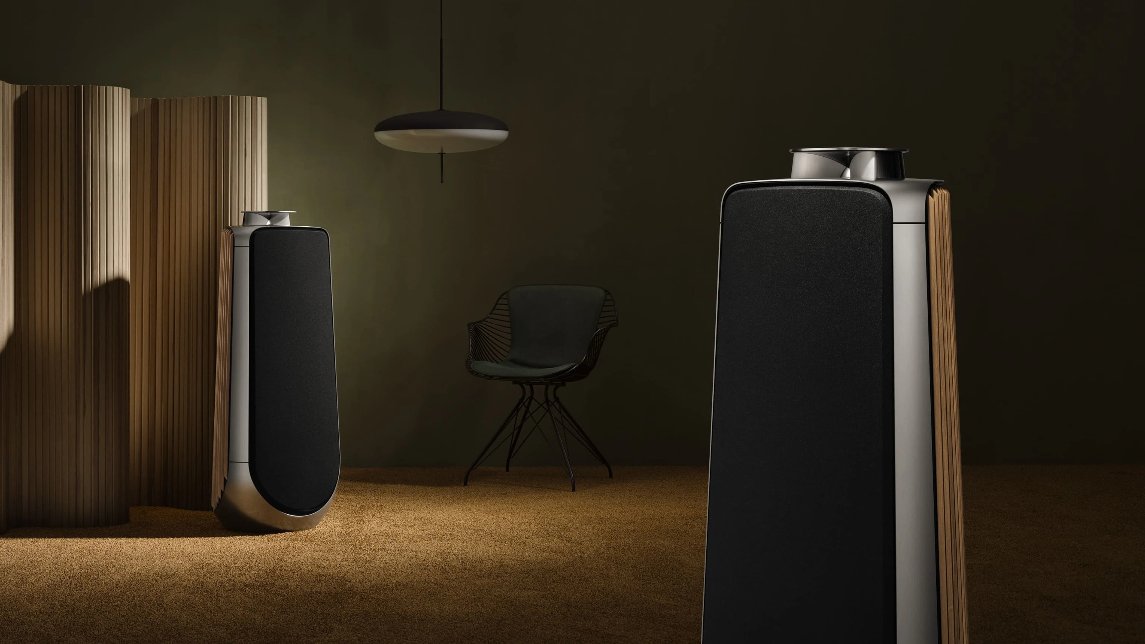 Two Beolab 50 in natural aluminum with black fabric front cover and oak wood side panels are in a room