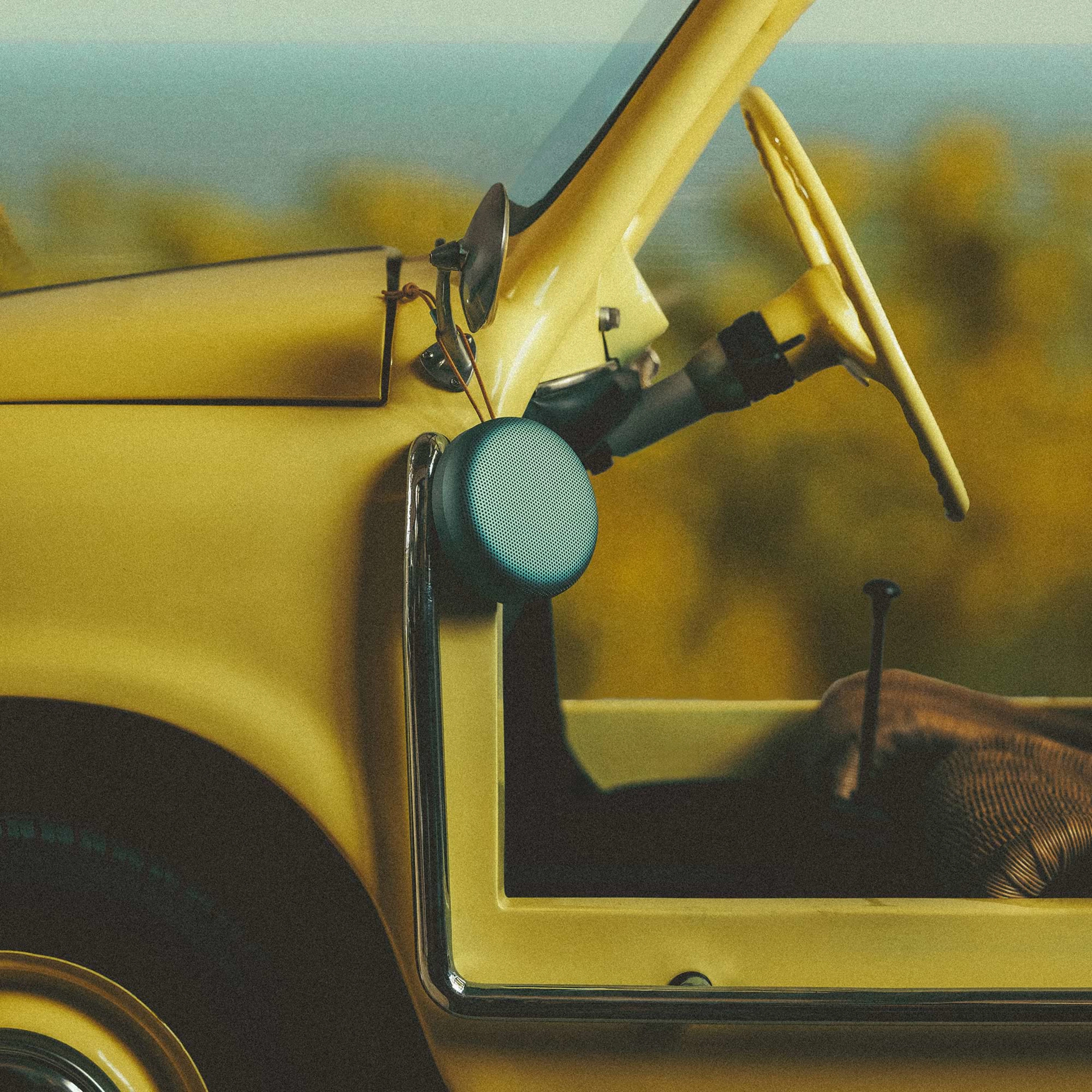 Beosound A1 3rd Gen hanging from a yellow Jeep