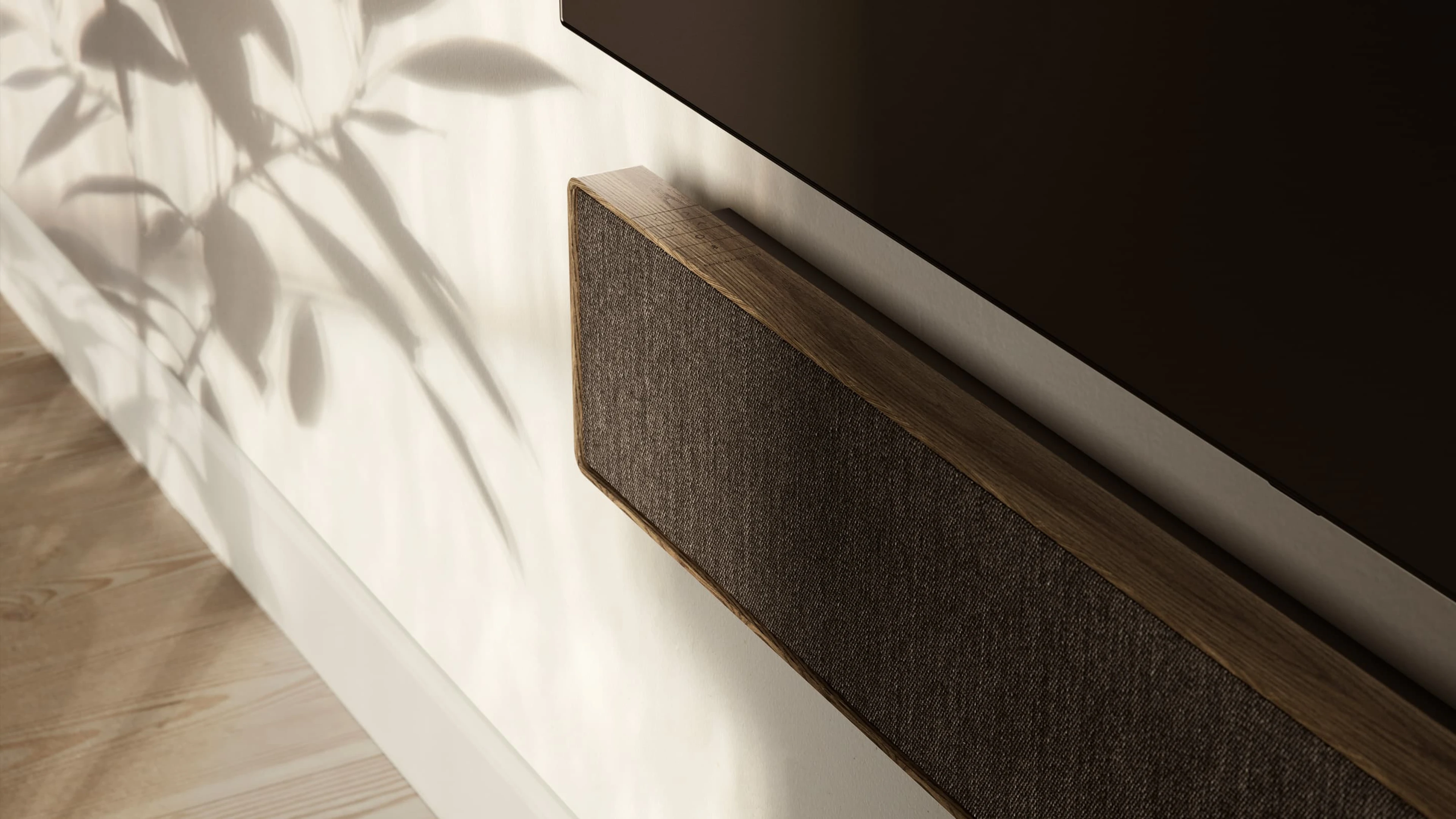 Smoked oak color Beosound Stage on the wall displayed under a TV