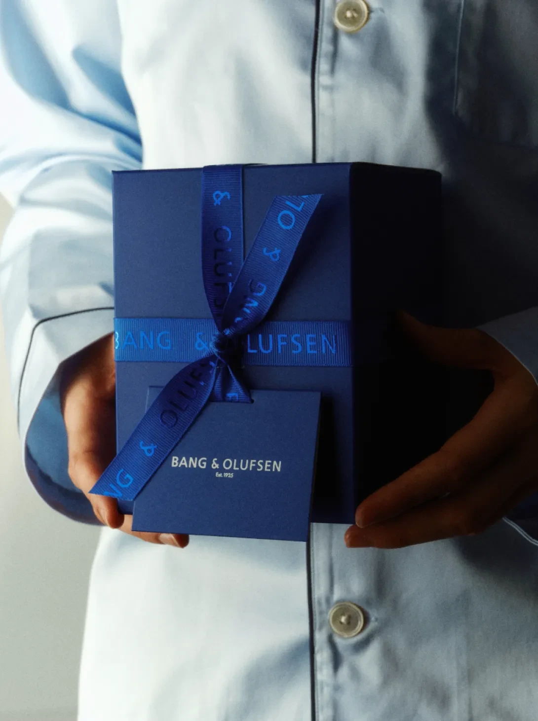 A woman in a blue shirt holding a gift