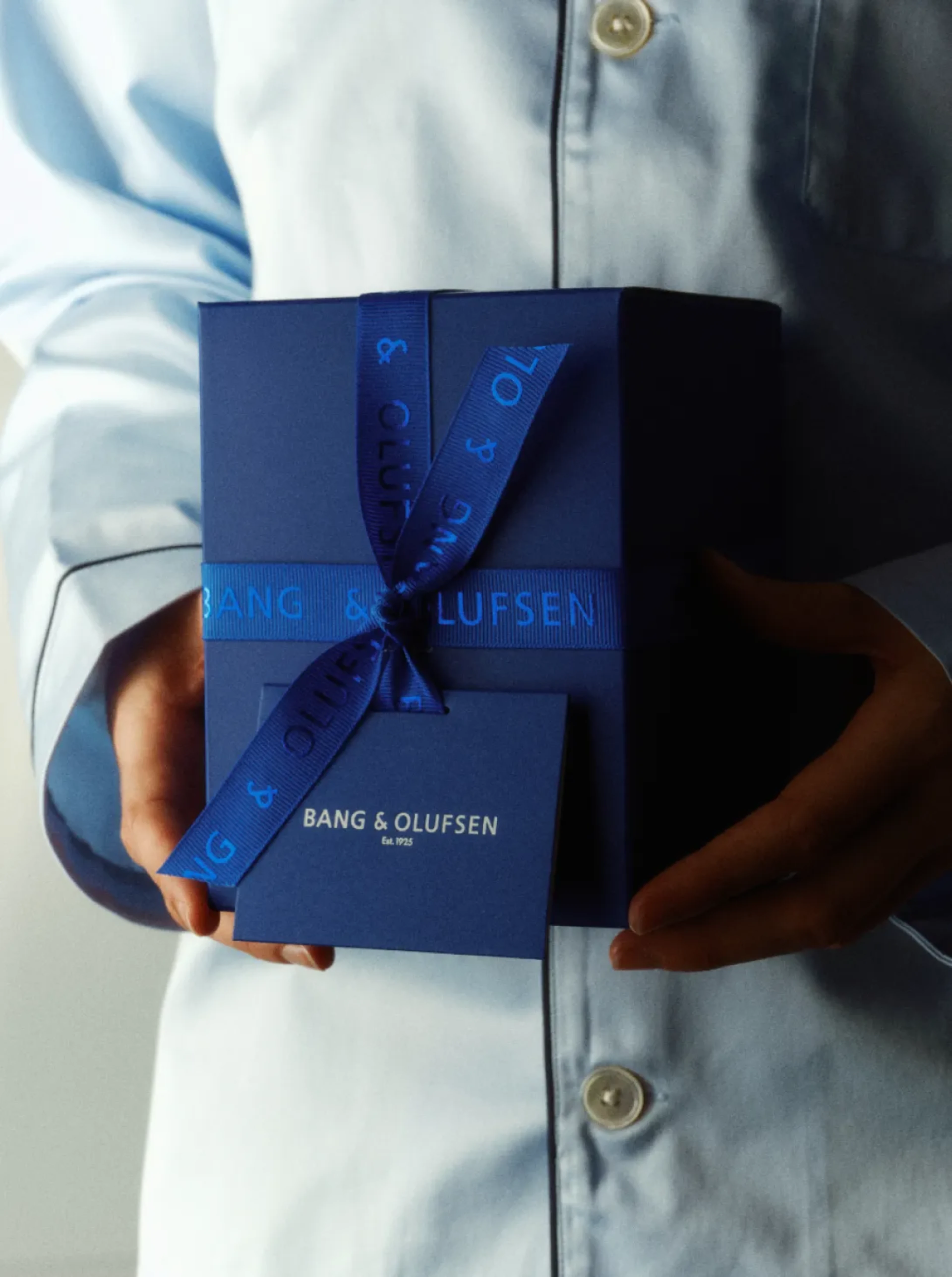 A woman in a blue shirt holding a gift
