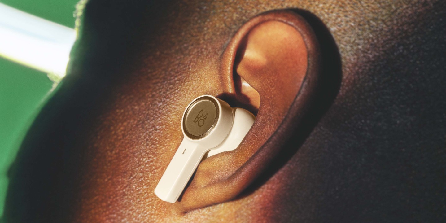 Detail of Beoplay EX gold in the ear of a man