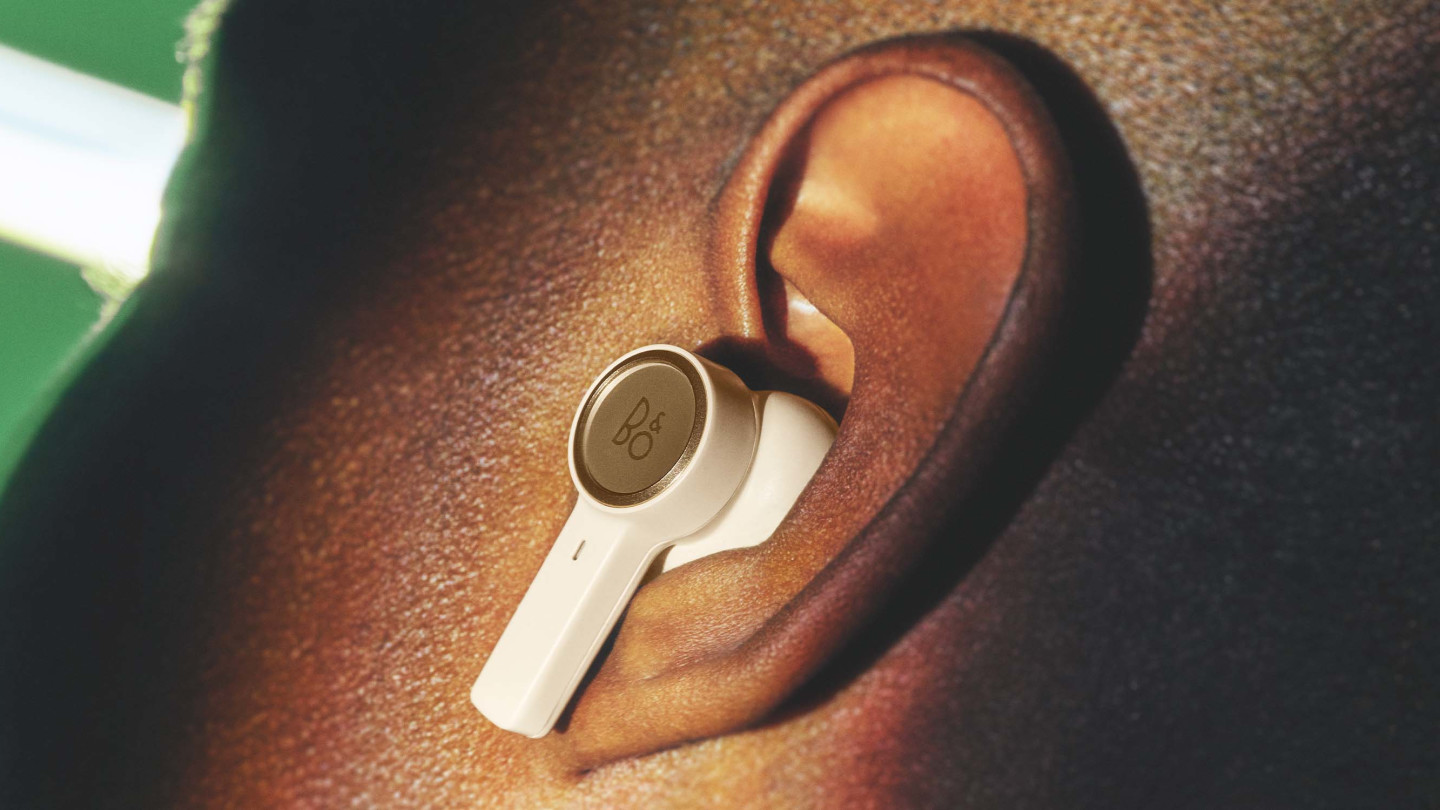 Detail of Beoplay EX gold in the ear of a man