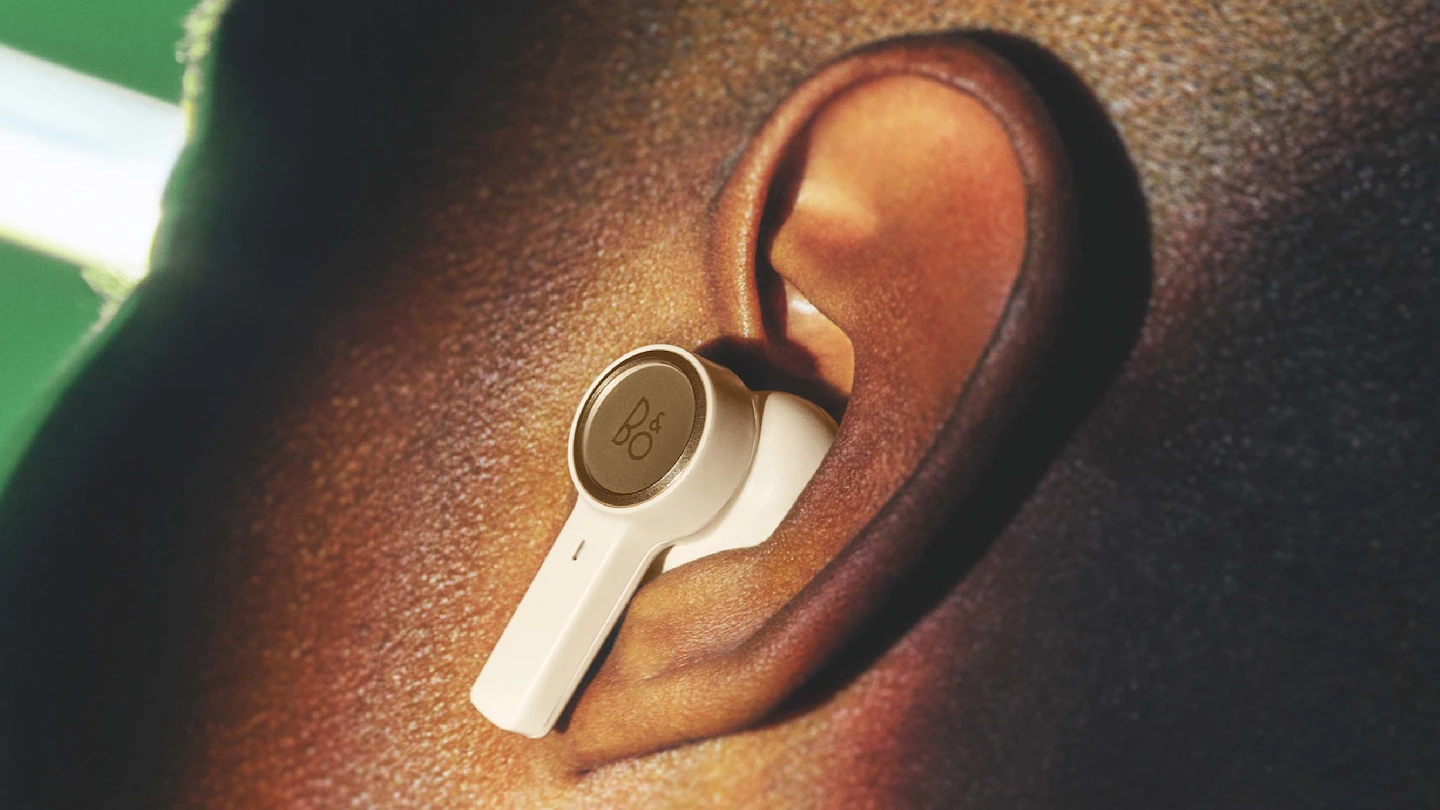 Detail of Beoplay EX gold in the ear of a man