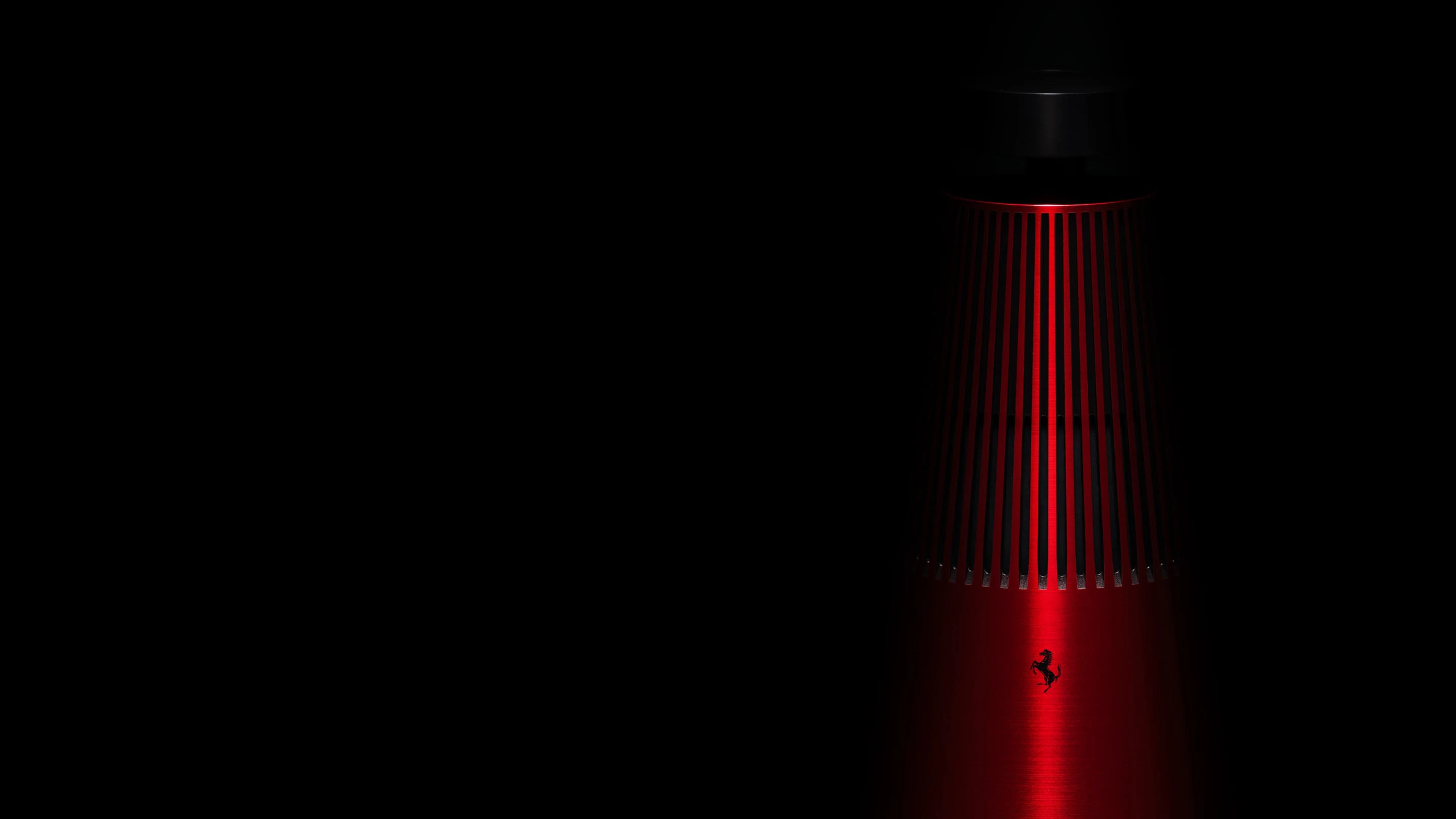 Beosound 2 Ferrari edition speaker on a dark black background and you can see the Ferrari logo on it