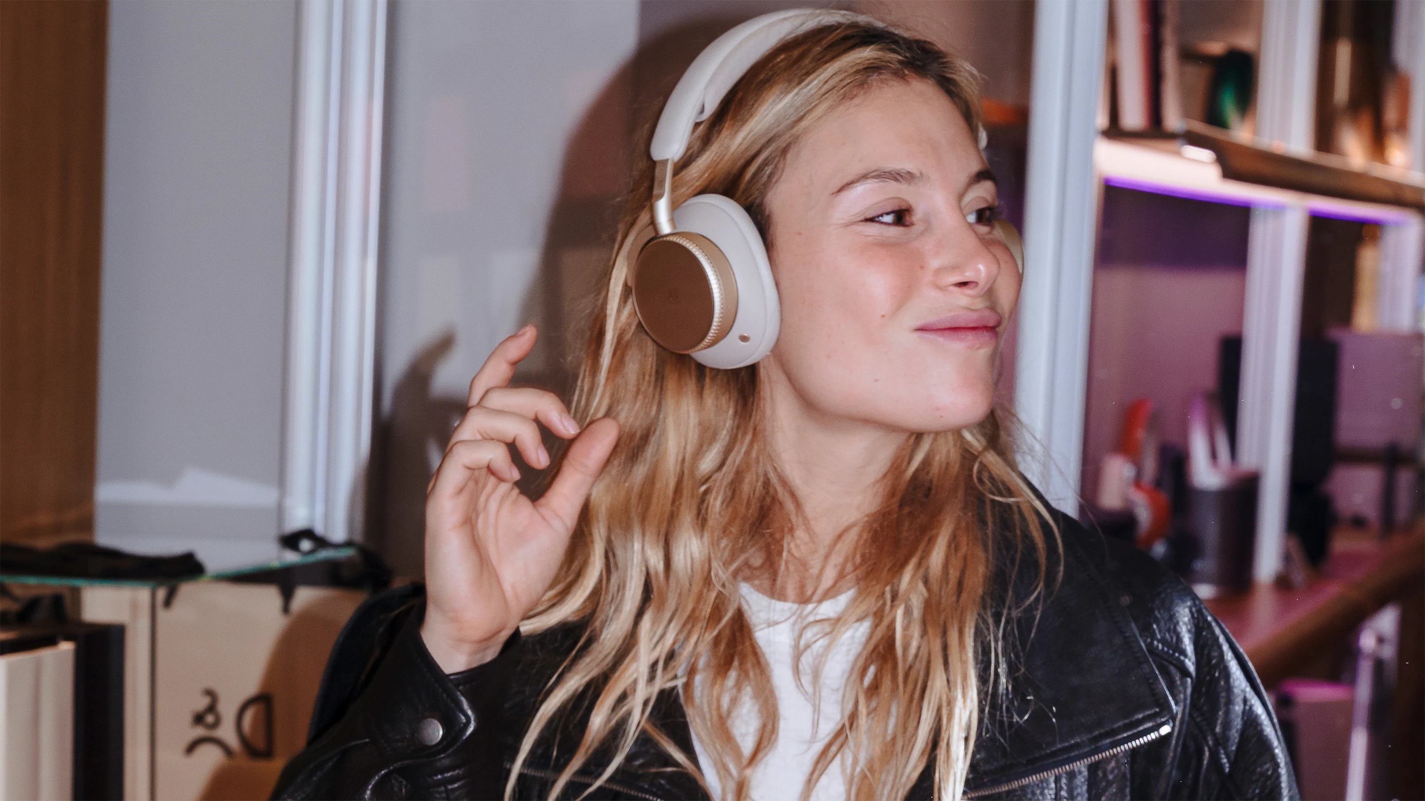 Woman smiling while wearing Beoplay H100 headphones 