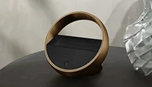 Beoremote Halo remote placed on wooden cabinet