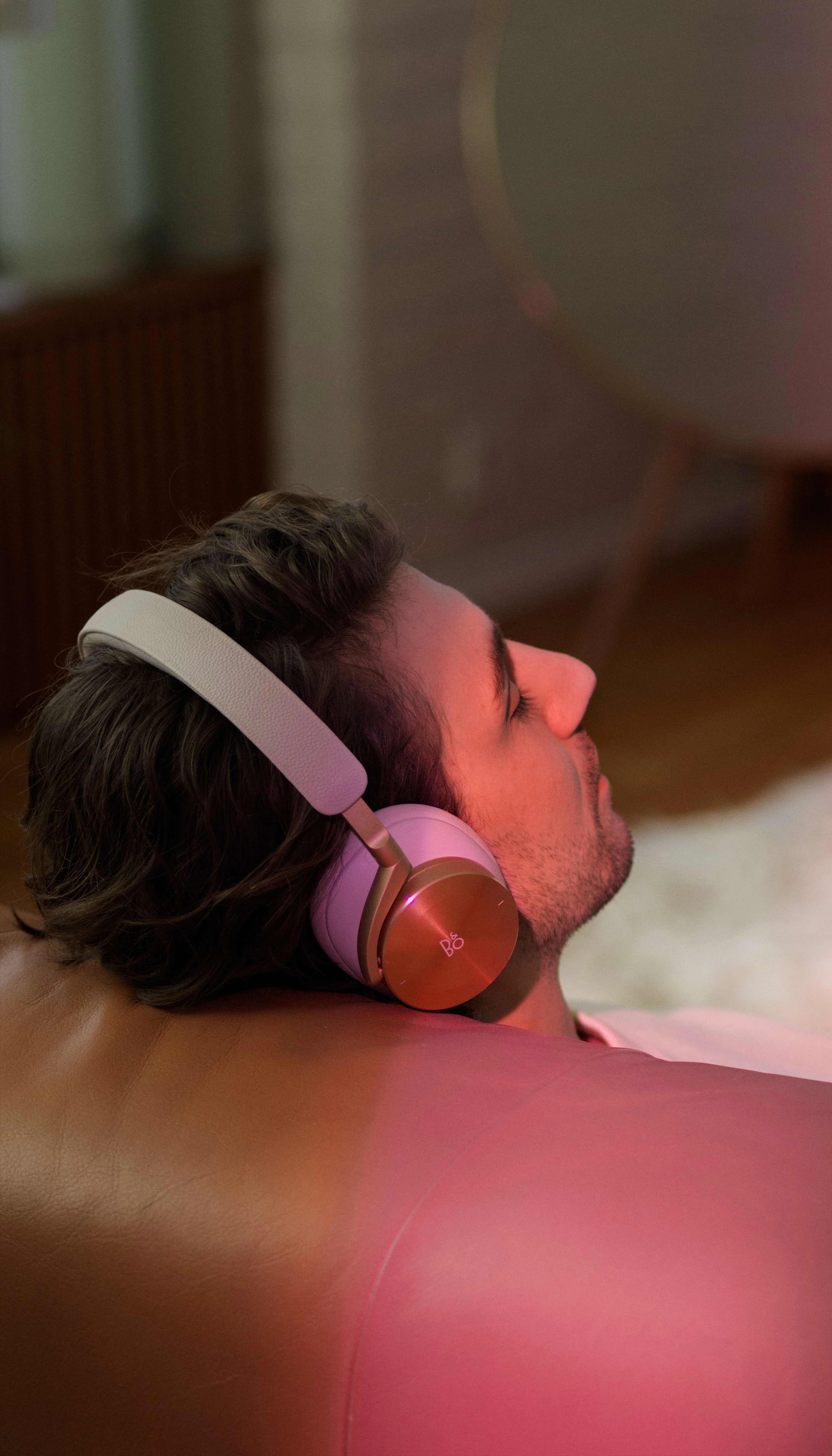 Man on the couch wearing Beoplay H95 Gold Tone