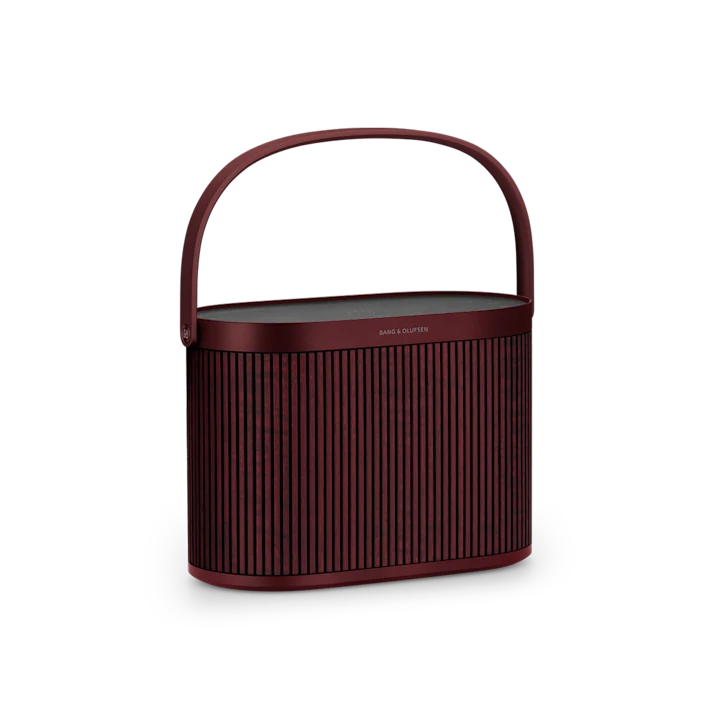 Beosound A5 Cranberry Red shown from the side with handle up