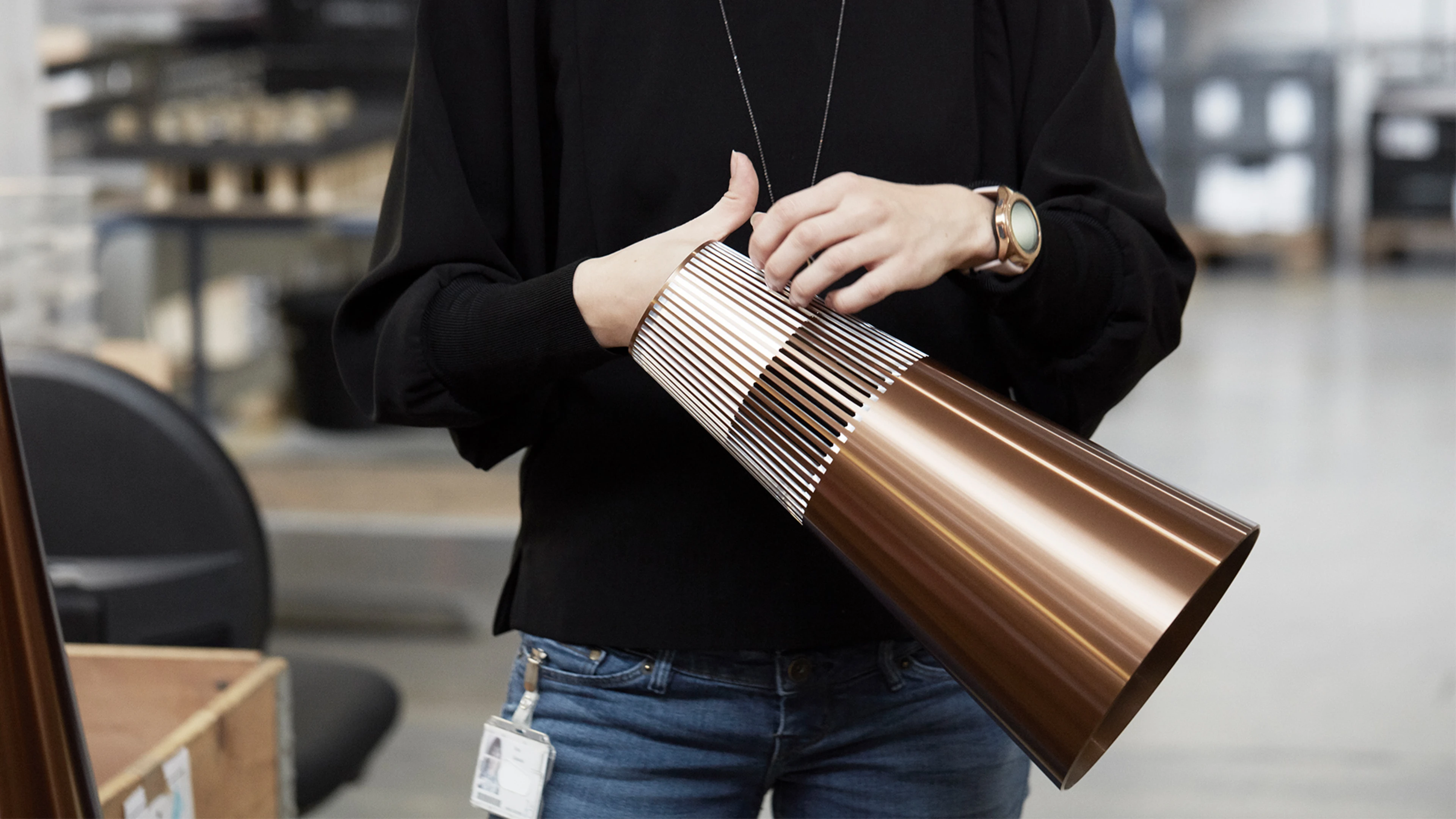 Britta holding a Beosound 2 in bronze in the factory