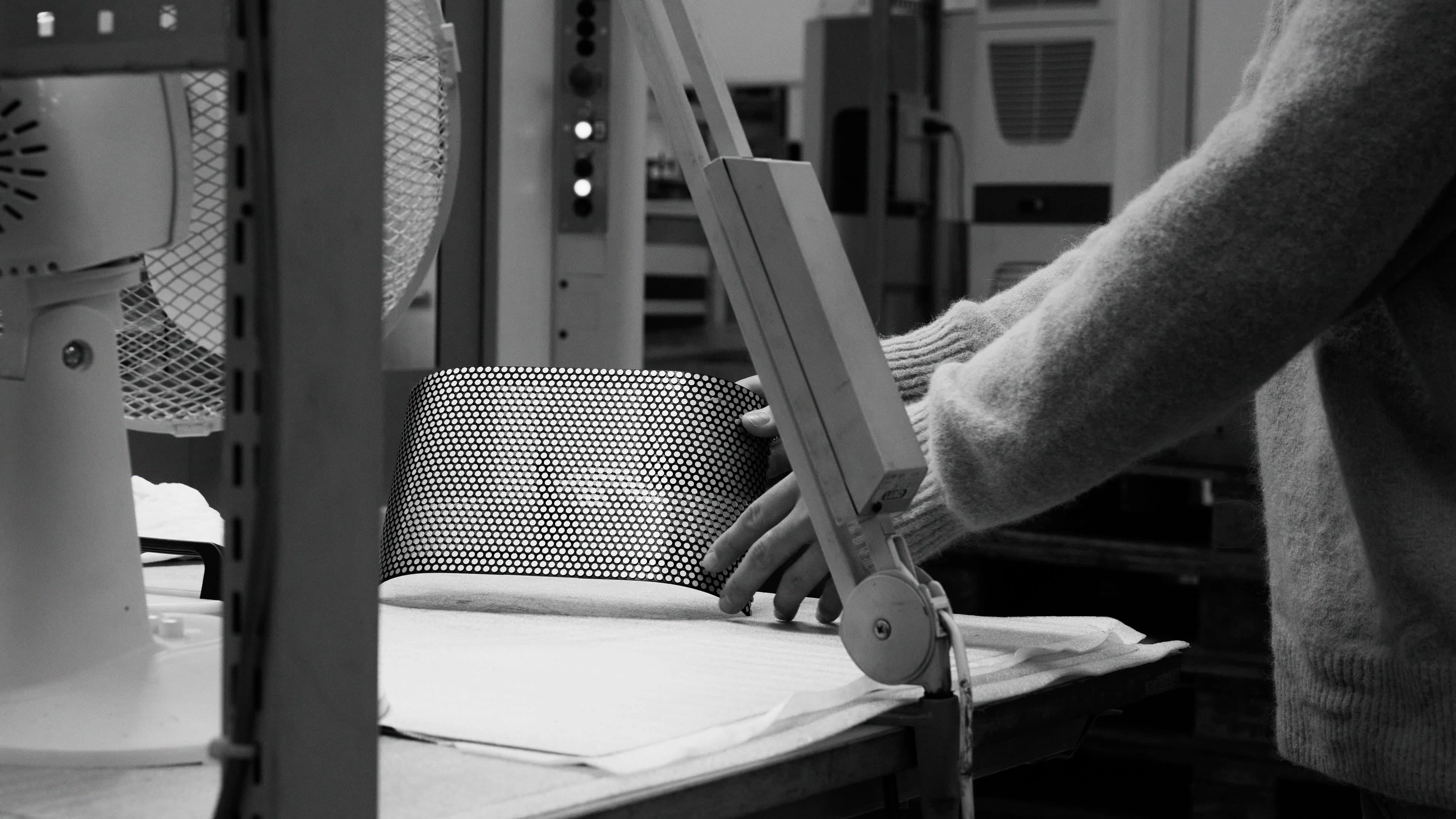 Image of a factory worker handling the Beosound A5 speaker cover in Spaced Aluminium