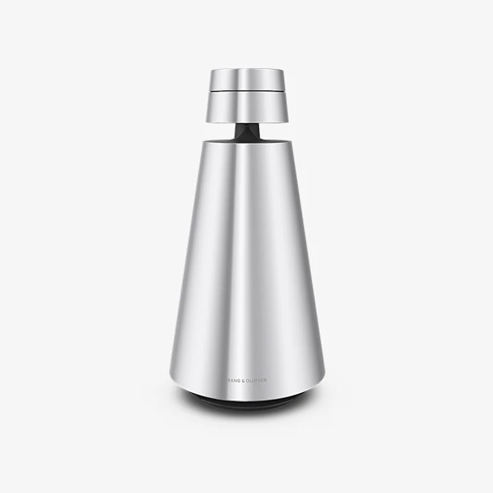 Beosound 1 speakers full on table in front of pink couch