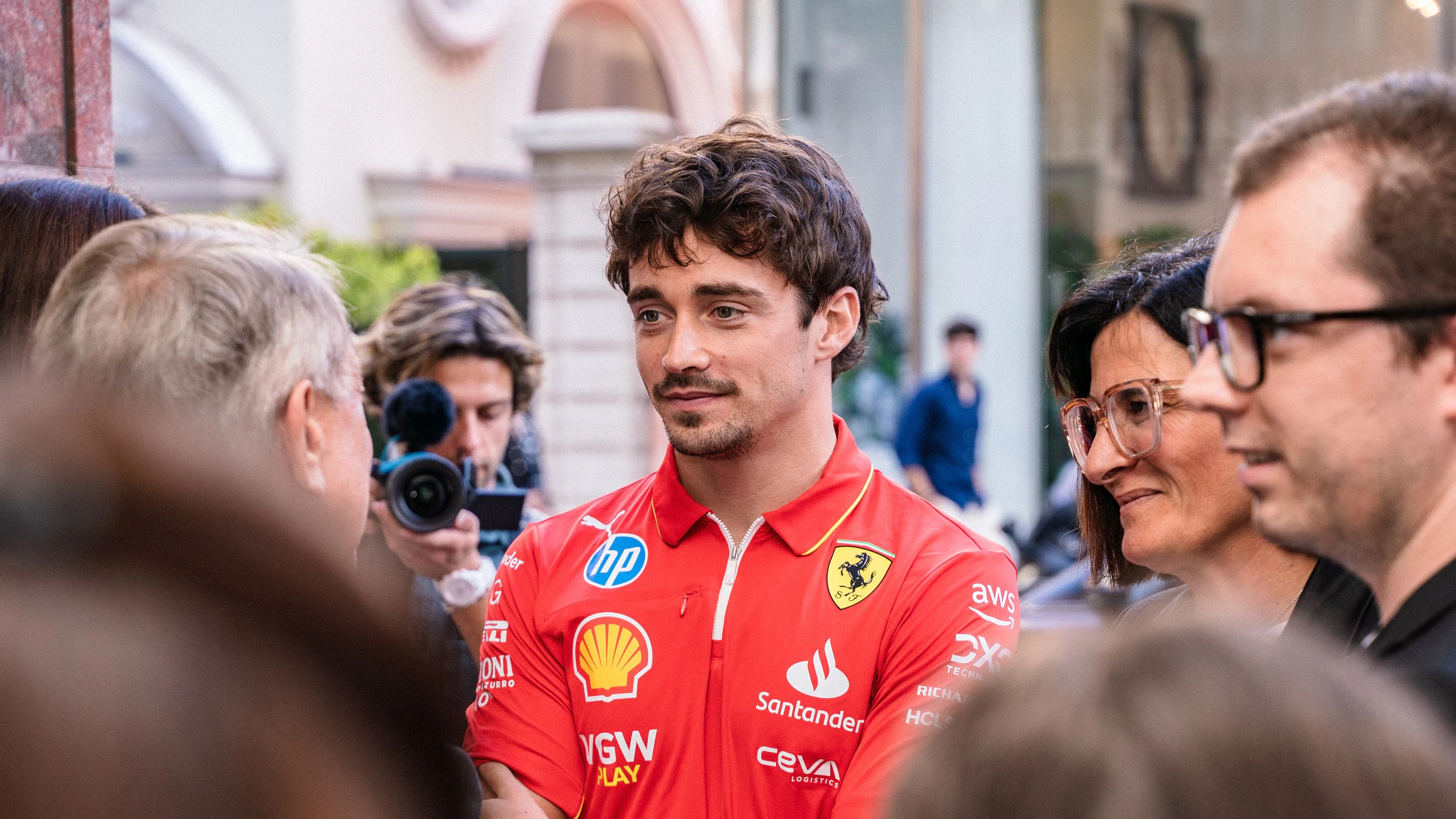 Scuderia Ferrari member stands in a crowd