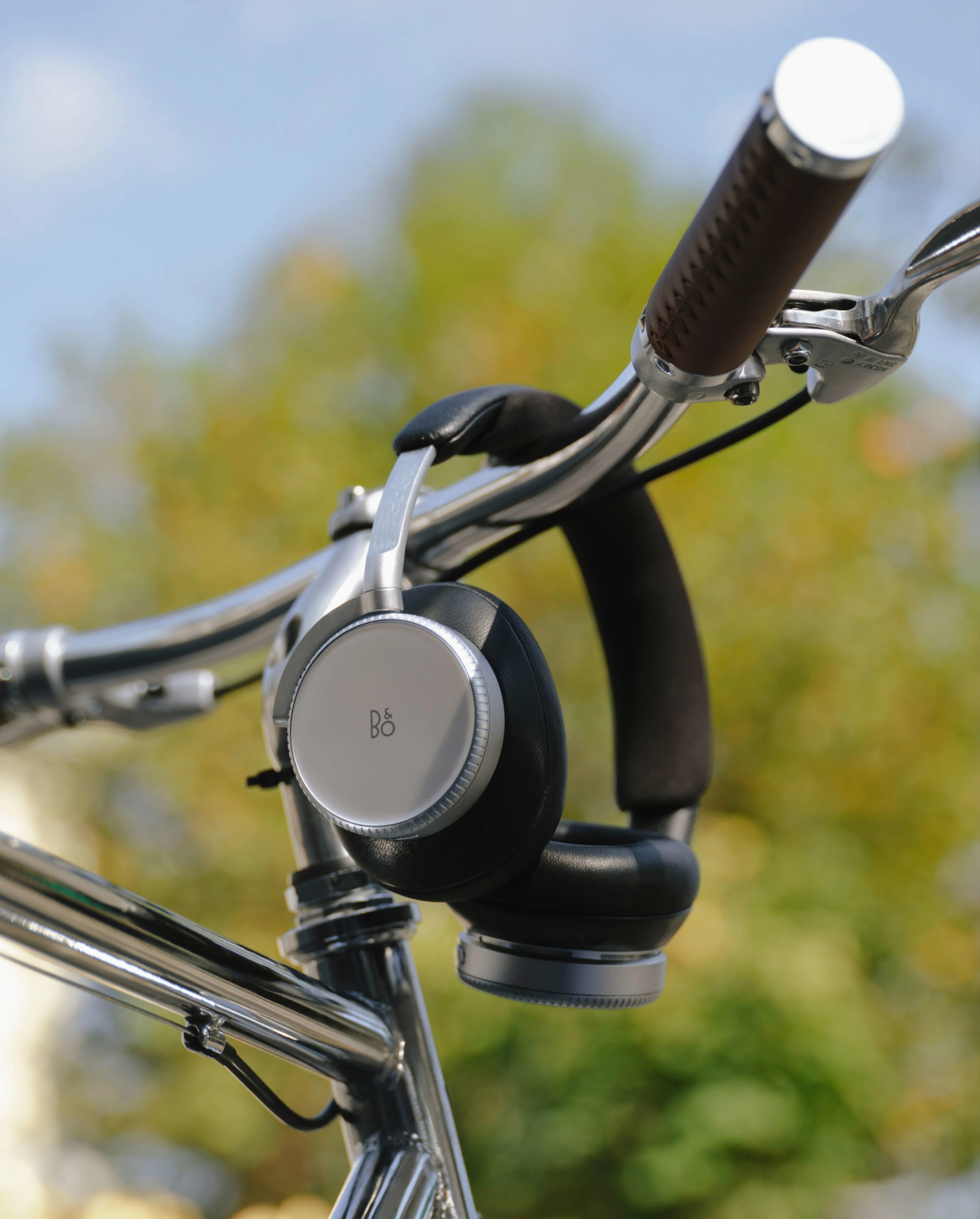 Beoplay H100 hanging on a bikes steer