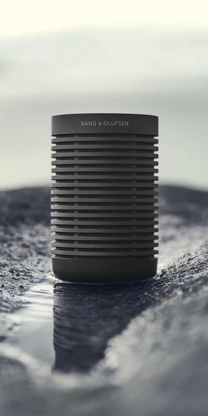 Beosound Explore outdoor speaker placed on top of wet terrain