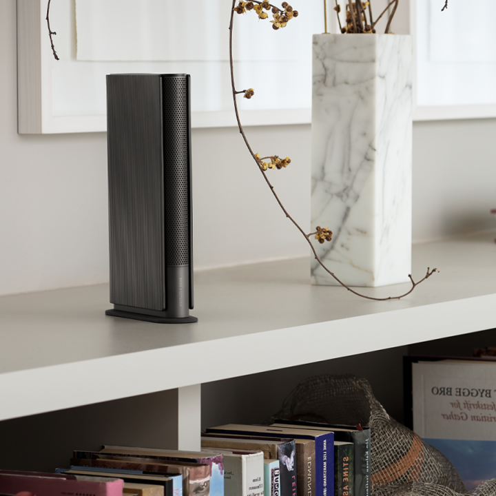 Beosound Emerge Black Anthracite on a bookshelf, in a bright spacious livingroom