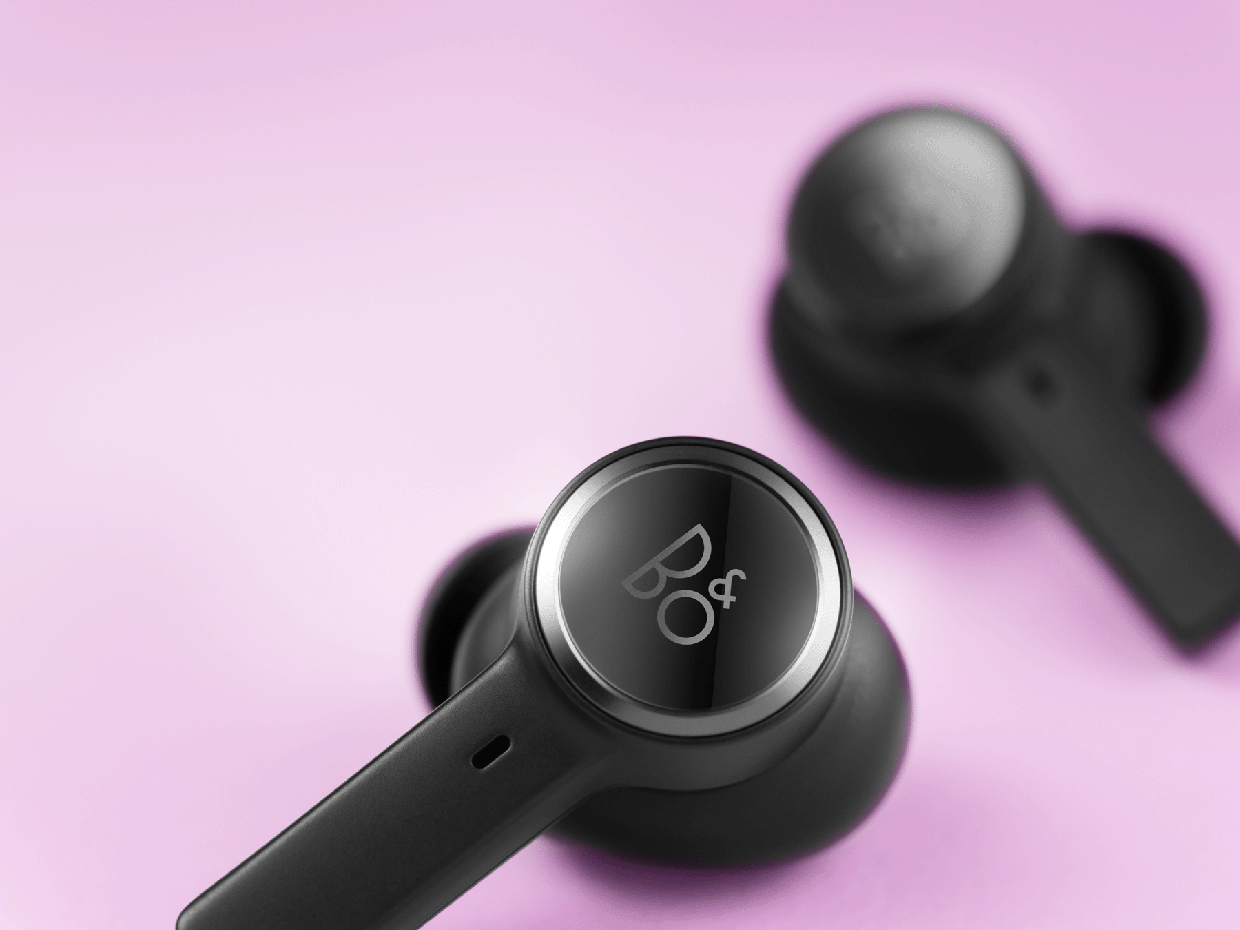 Man holding Beoplay EQ earphones in black color in his hands