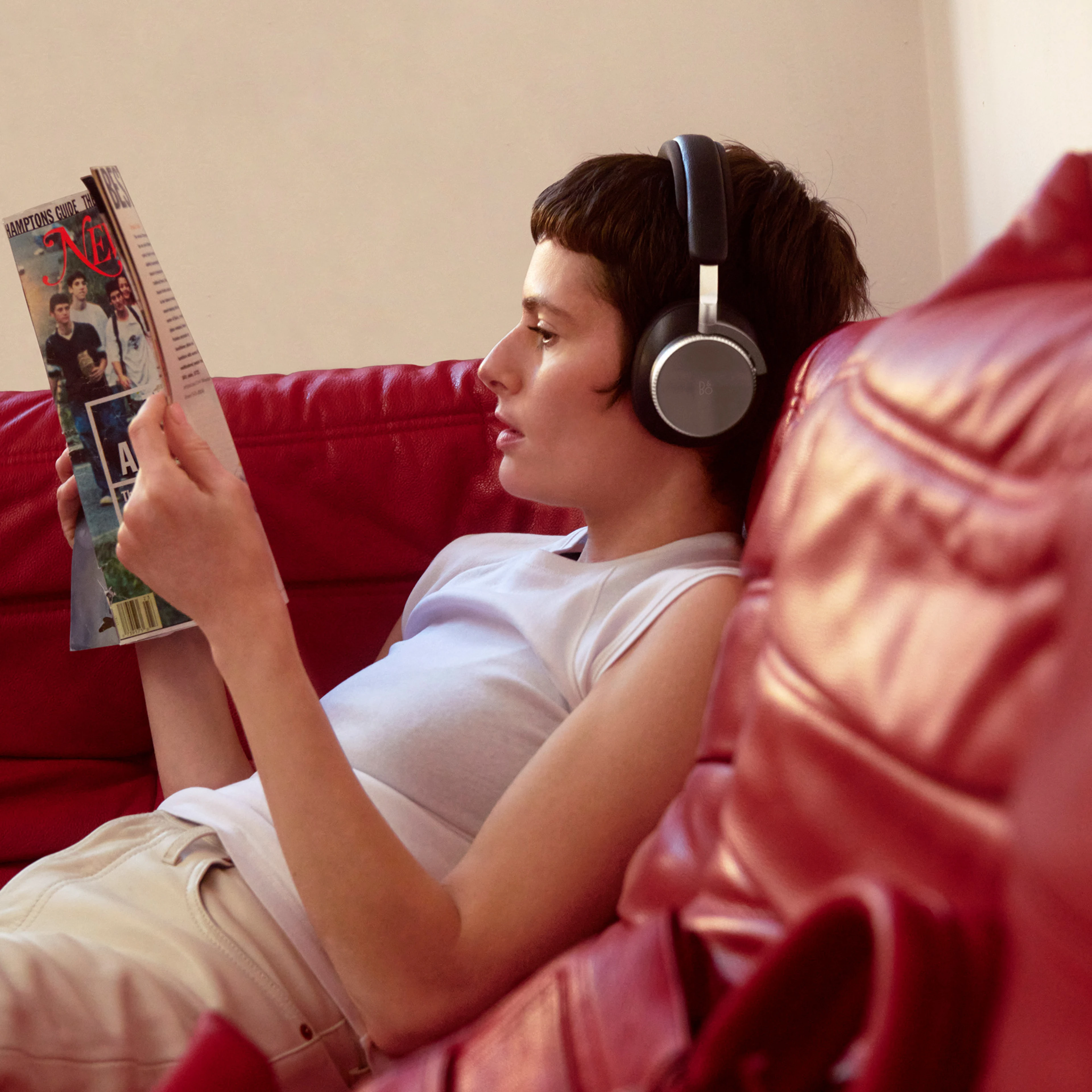 Camilla sitting on the couch with Beoplay H100