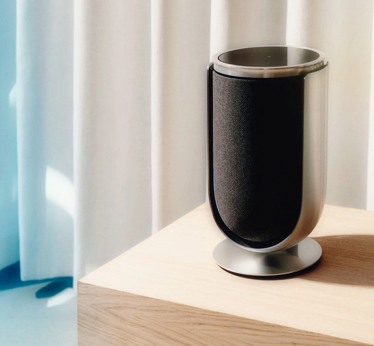 Beolab 8 in Natural Aluminium with Grey Fabric cover on table stand