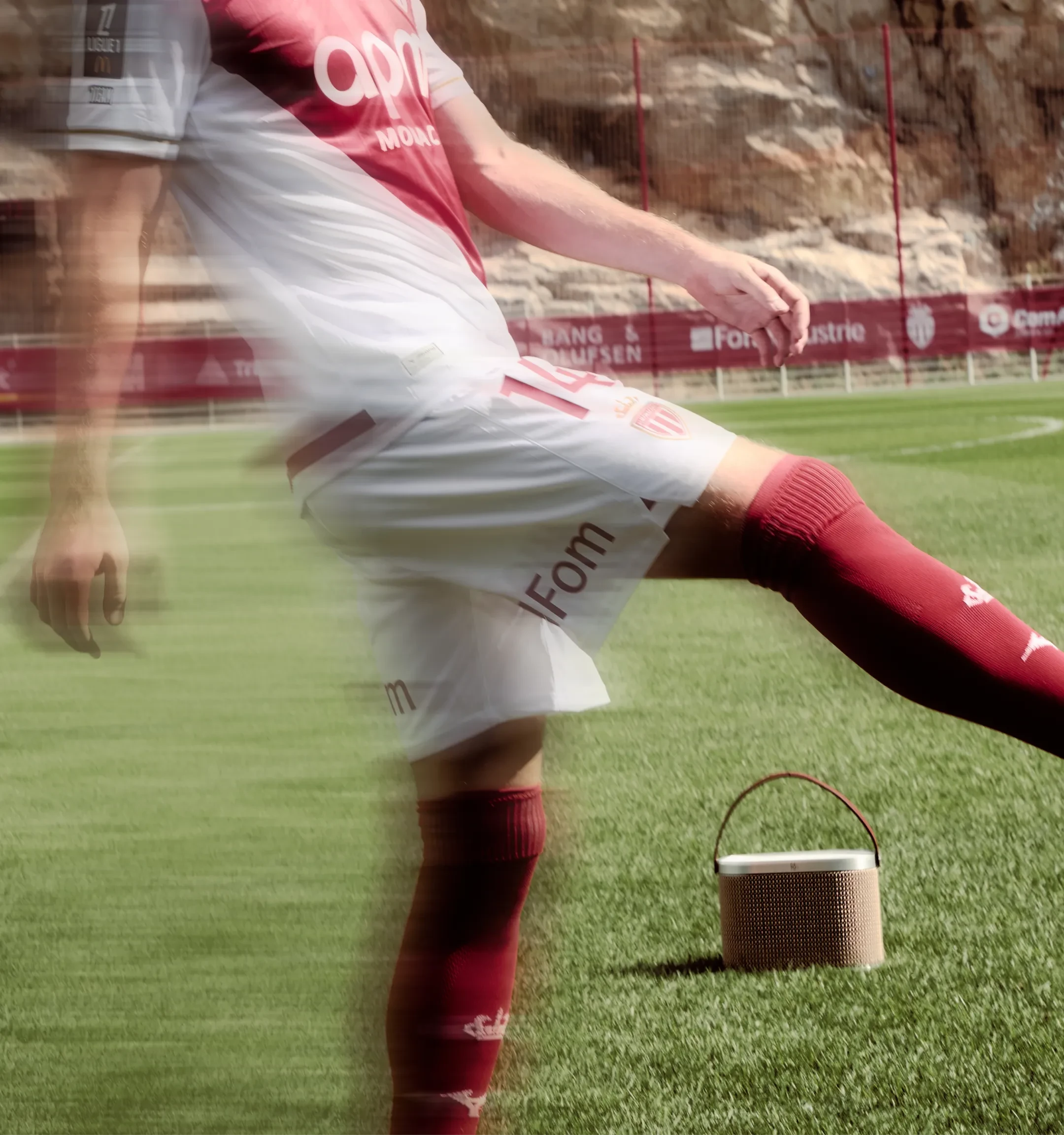 AS Monaco player kicking a ball and Boeosund A5 Centennial variant on the field, in the background