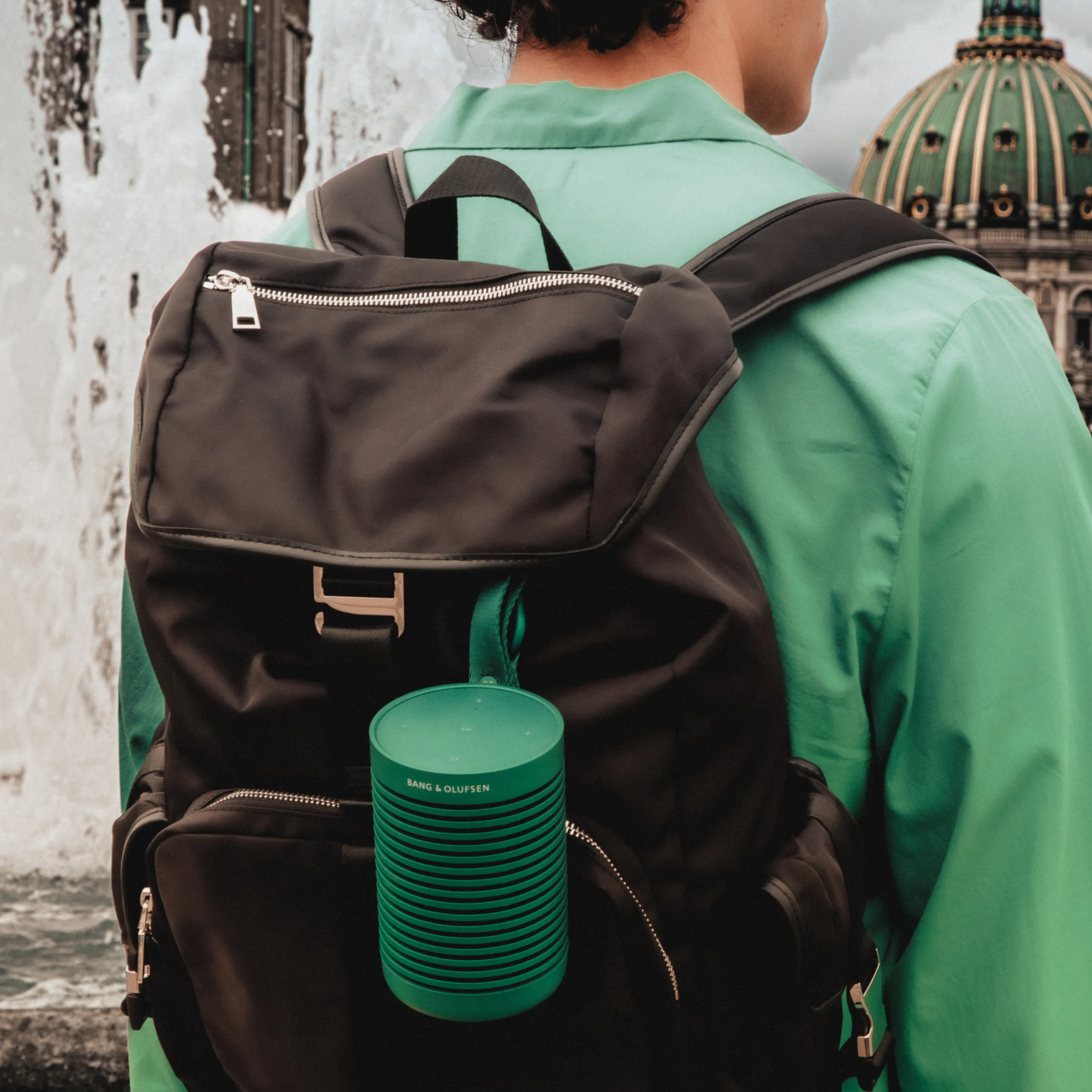 Beosound Explore Green hanging on a black backpack