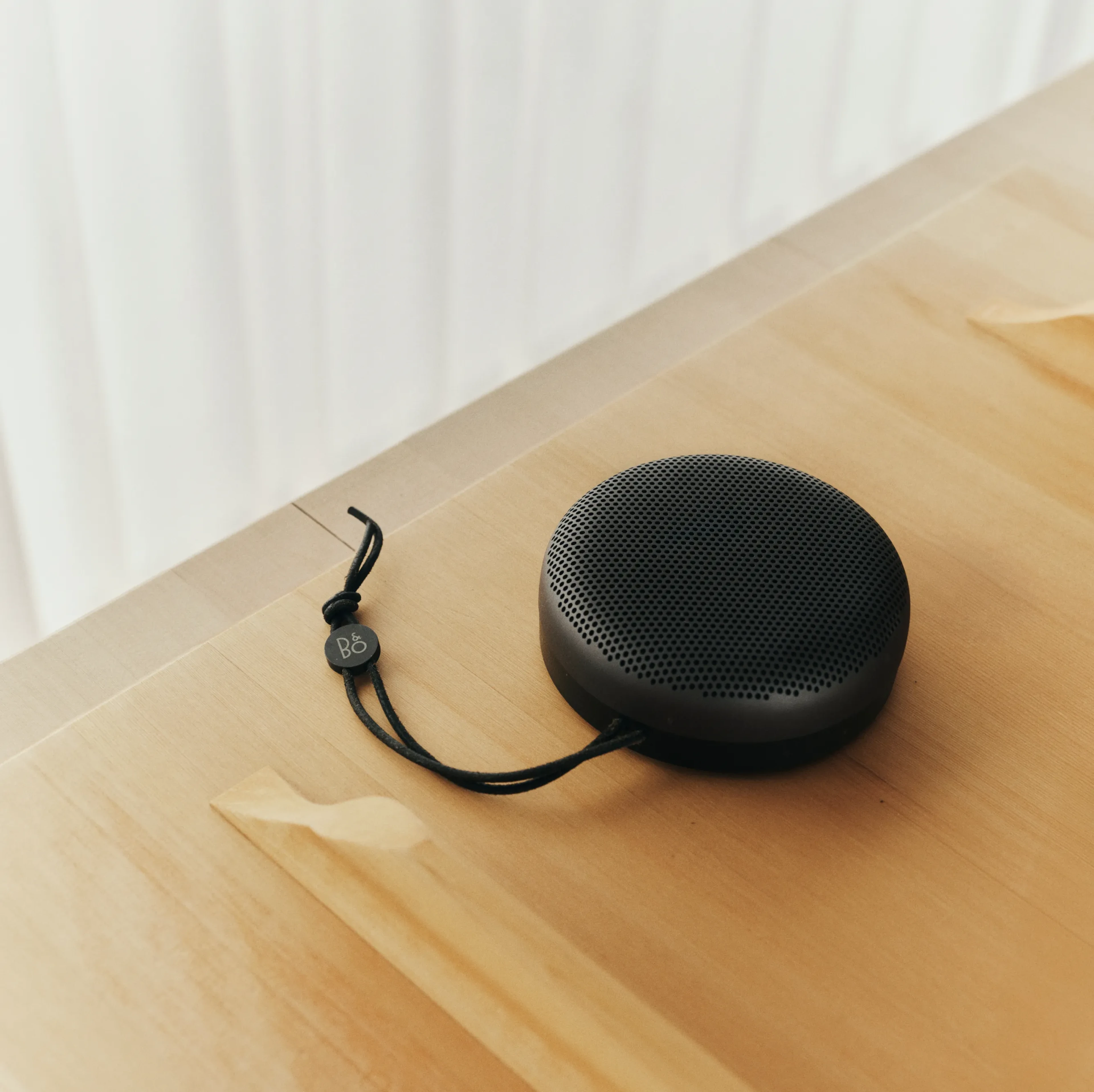 En sort Beosound A1 på et træbord