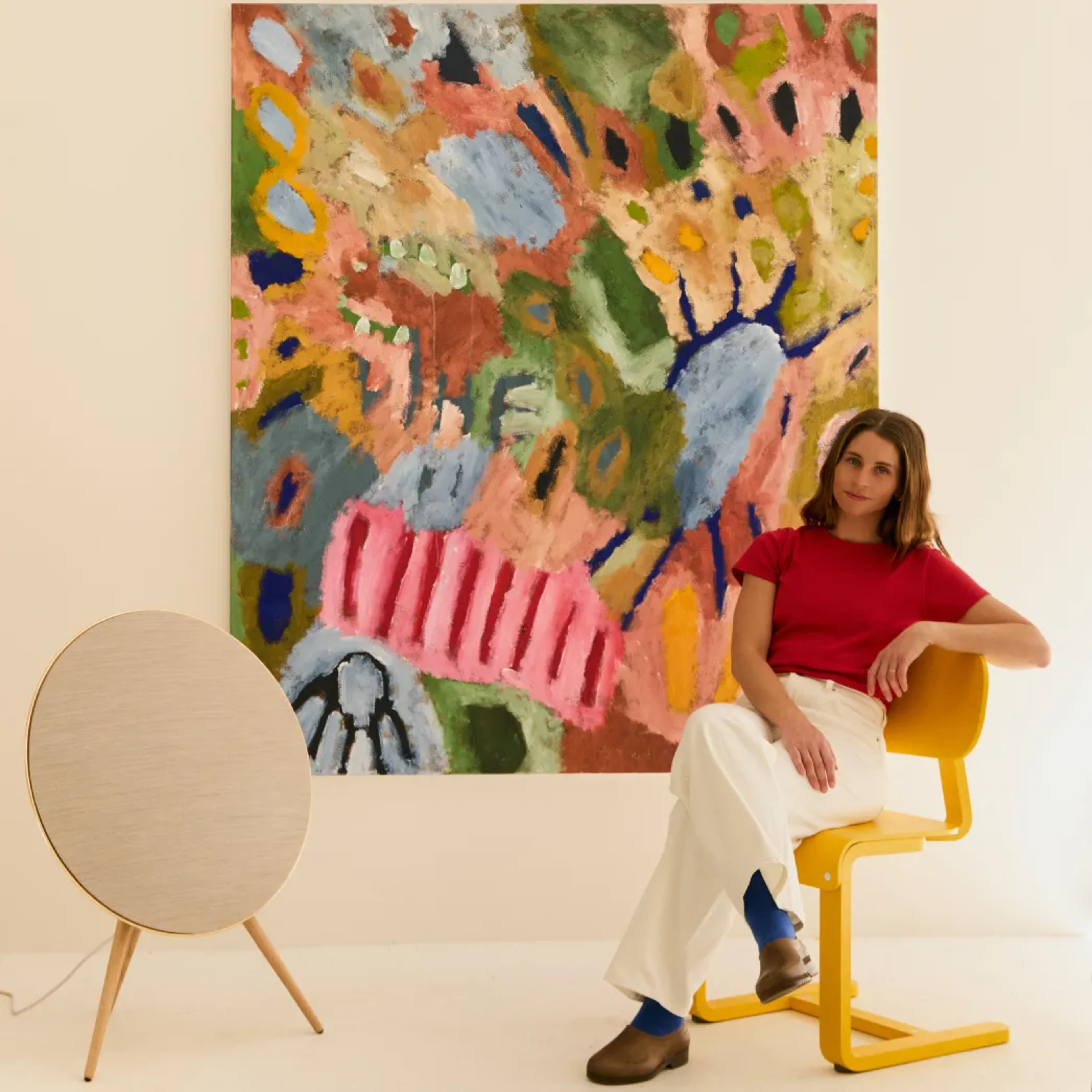 An artist Holly Terry working posing in front of the canvas with Beosound A9 for the Art of A9 Collboration