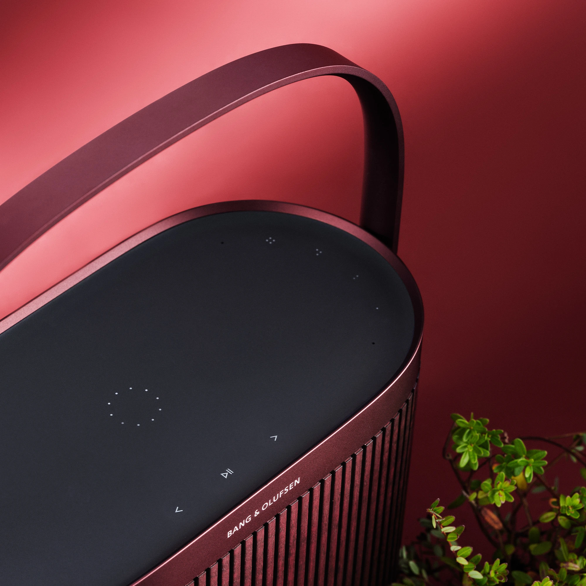 Beosound A5 Cranberry Red displayed in a red background with cranberries