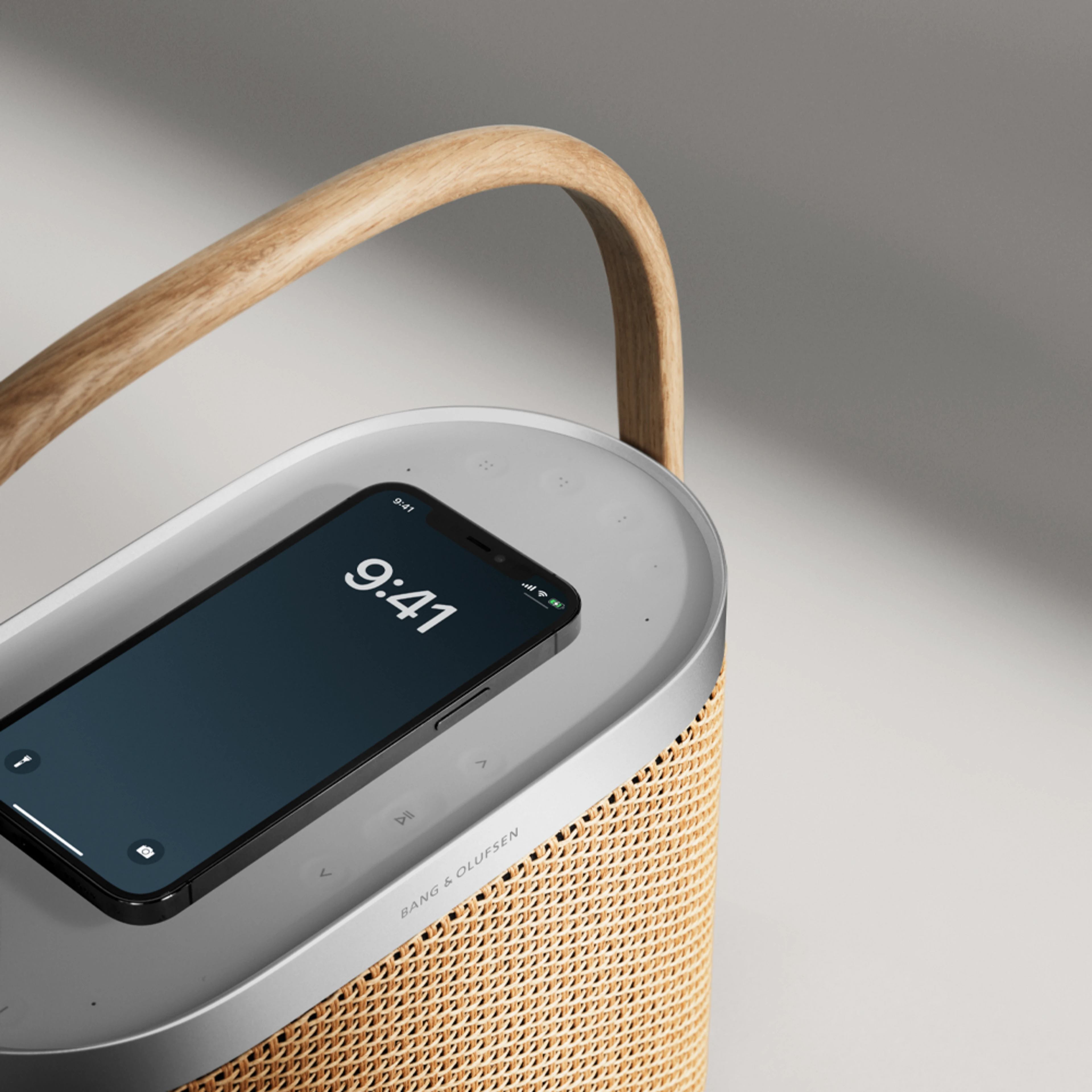 Image of Beosound A5 in Nordic Weave with phone on the speaker