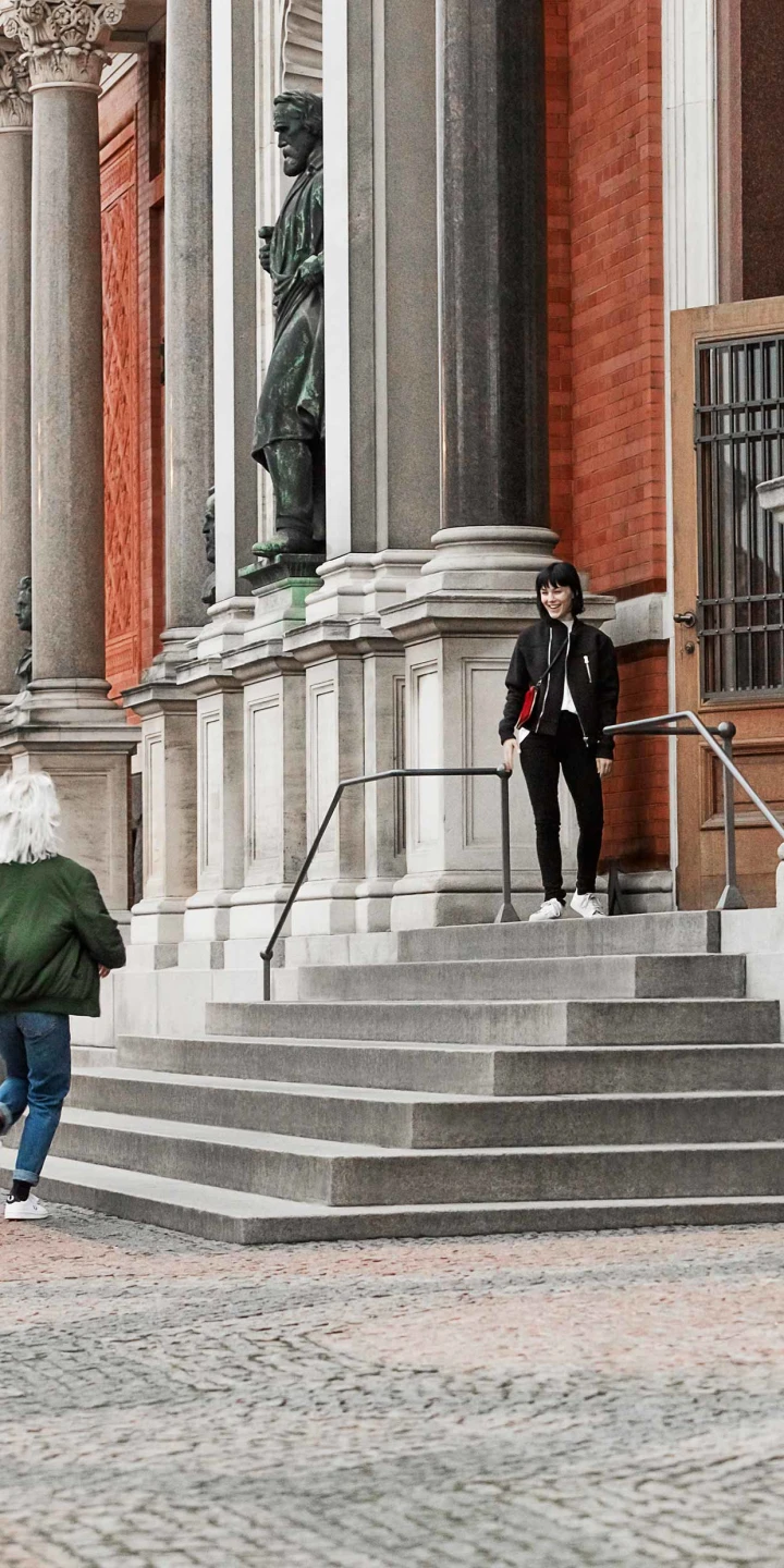 Beoplay M5 speakers two girls on the stairs of an old building