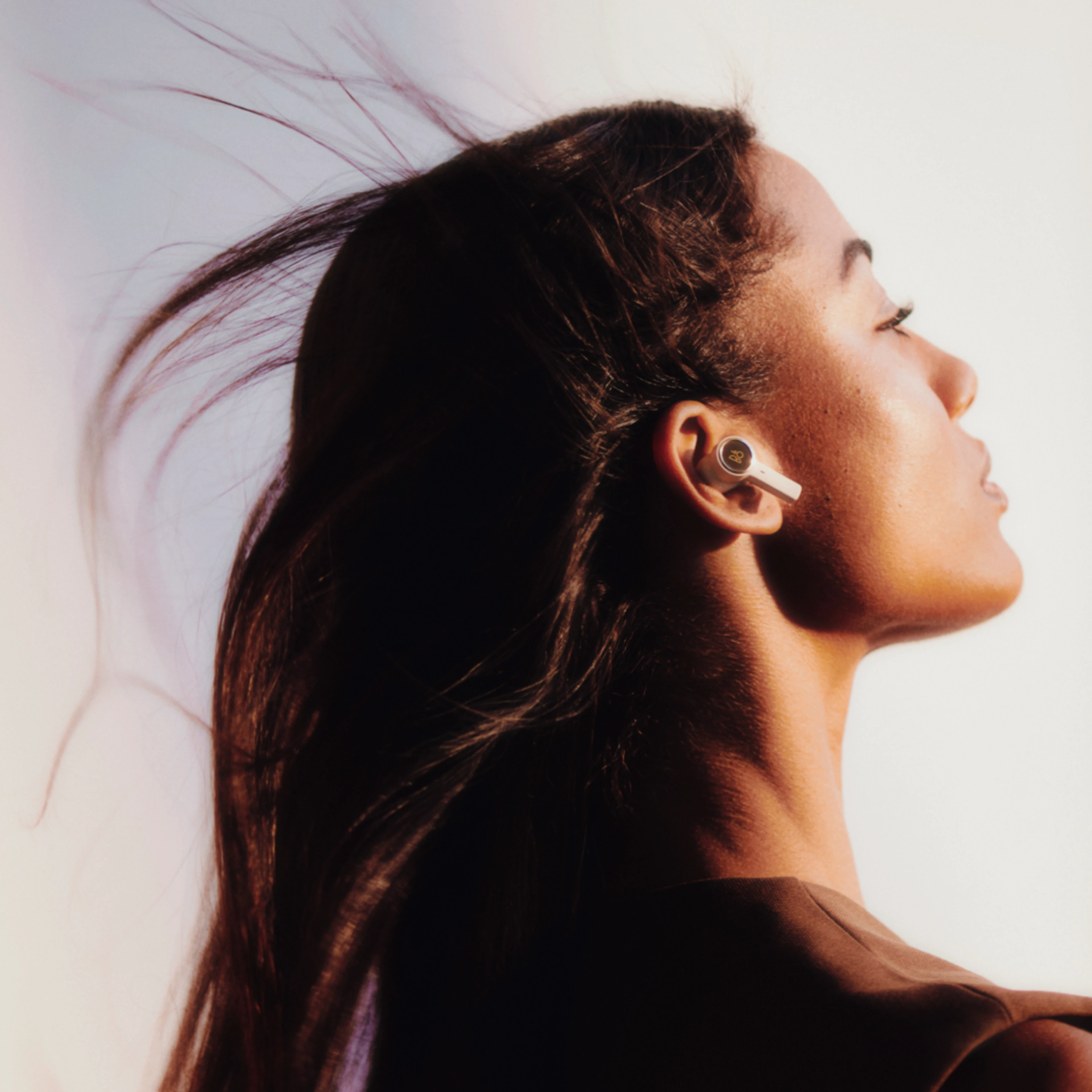 Woman wearing Beoplay EX in gold tone