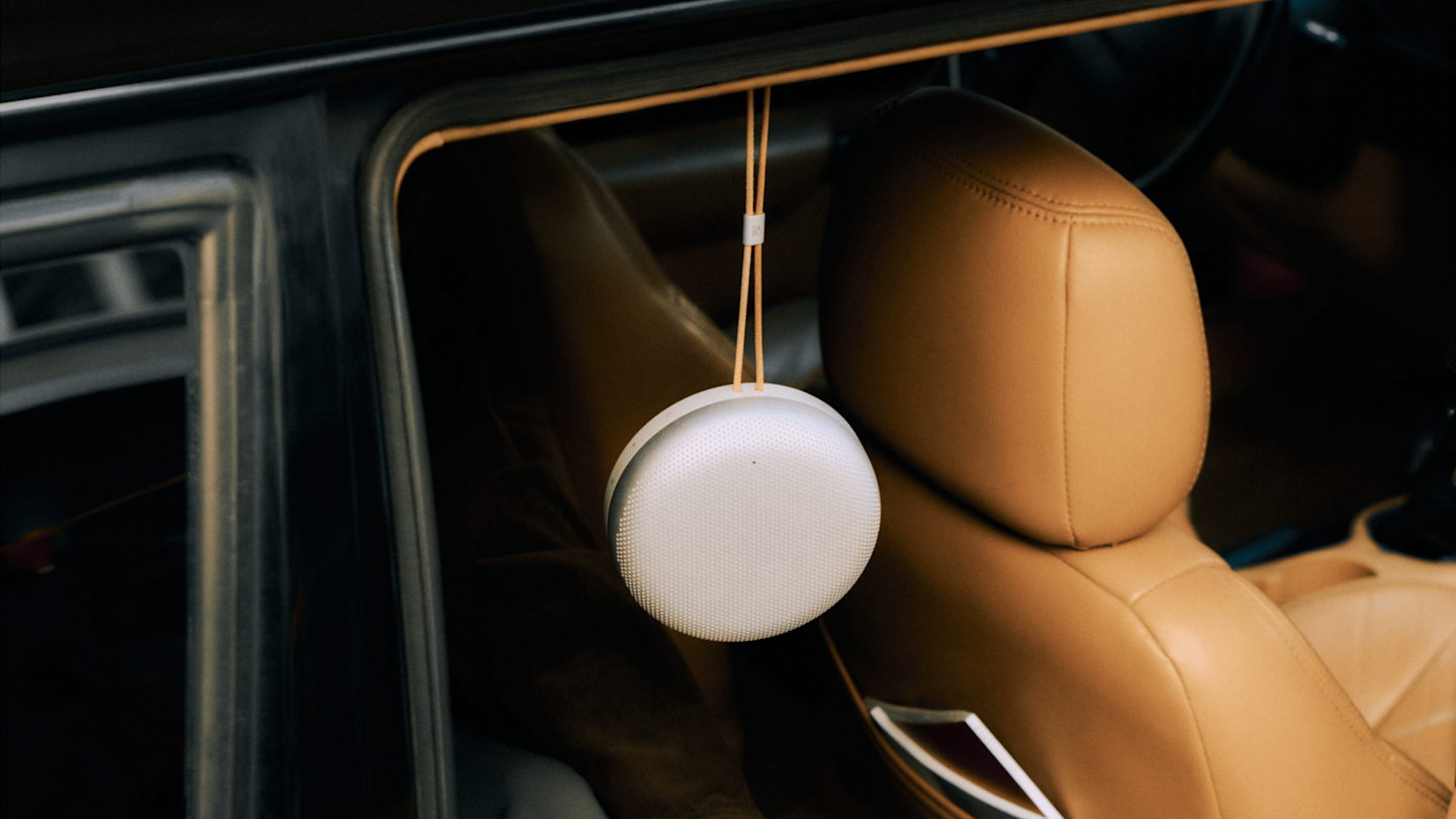Beosound A1 3rd Gen hanging from the door of a car