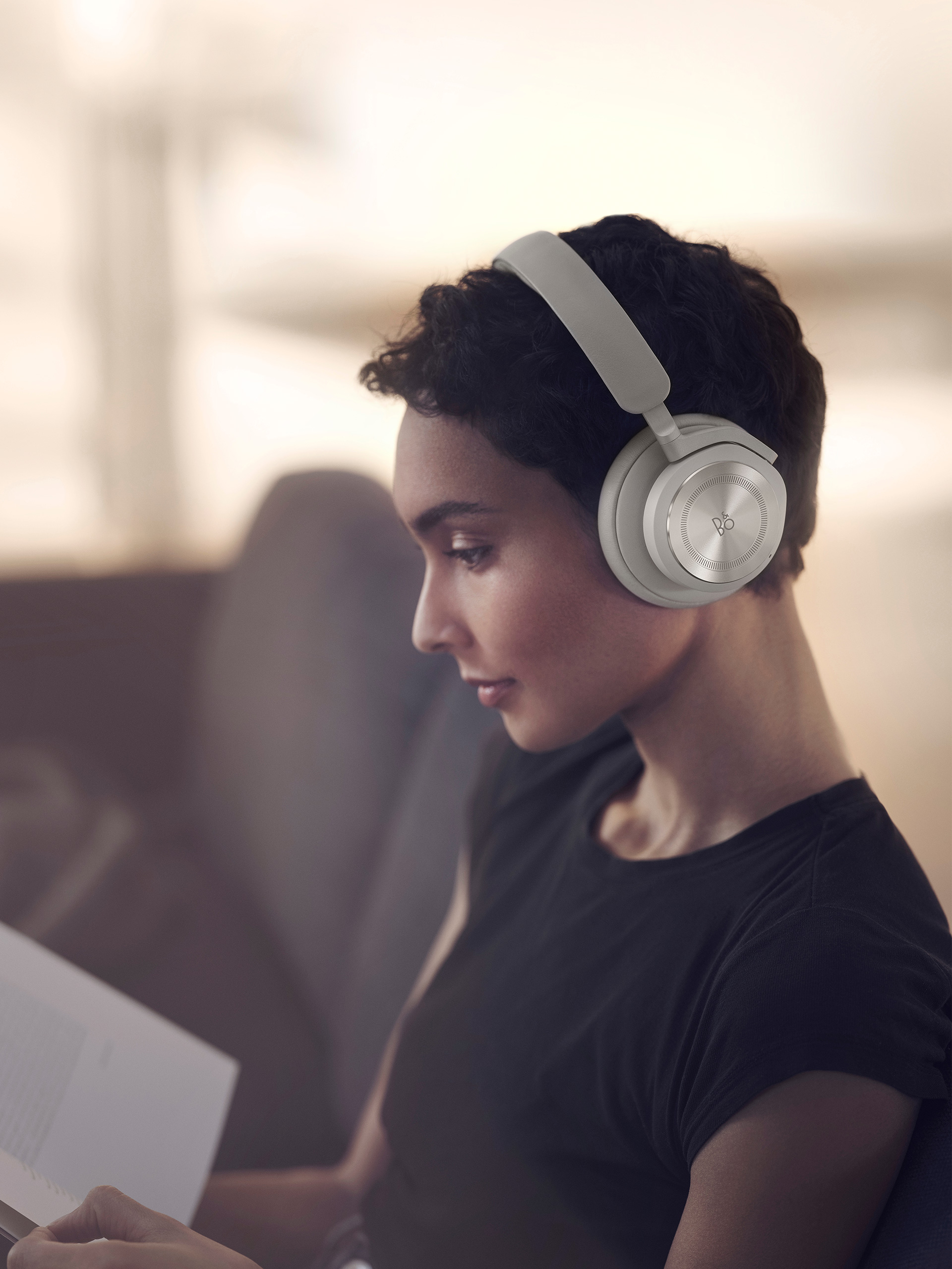 A woman wearing Beoplay HX Sand while working