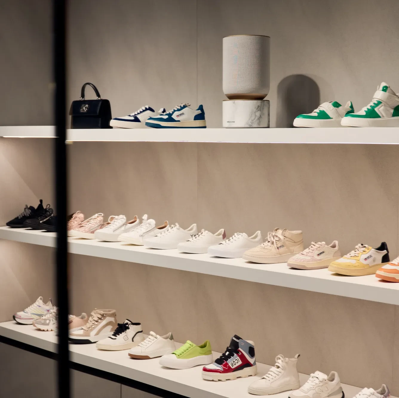 Image from Amicis store in Vienna where the Beosound Balance is displayed on the shelf above the shoes.