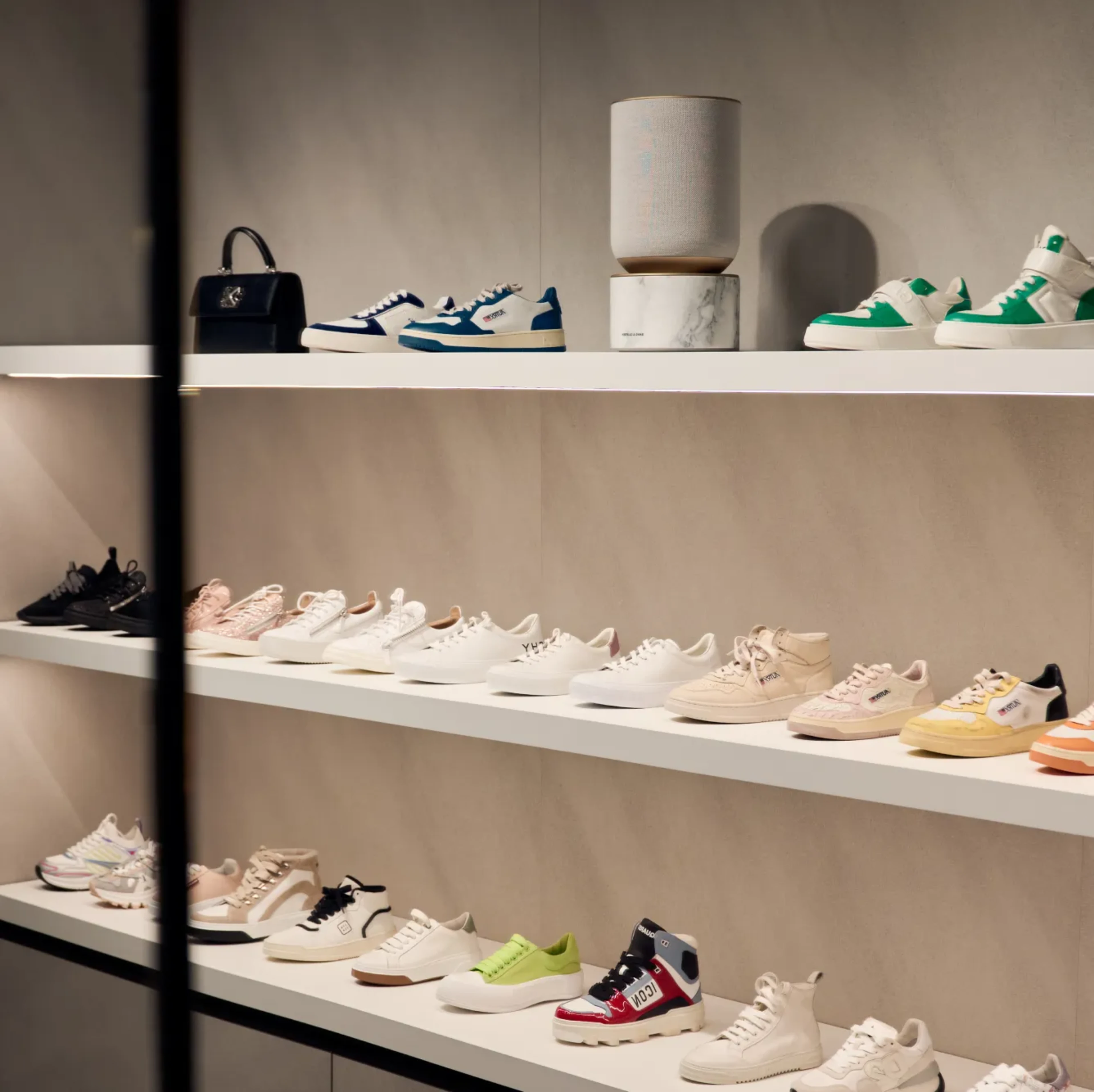 Image from Amicis store in Vienna where the Beosound Balance is displayed on the shelf above the shoes.