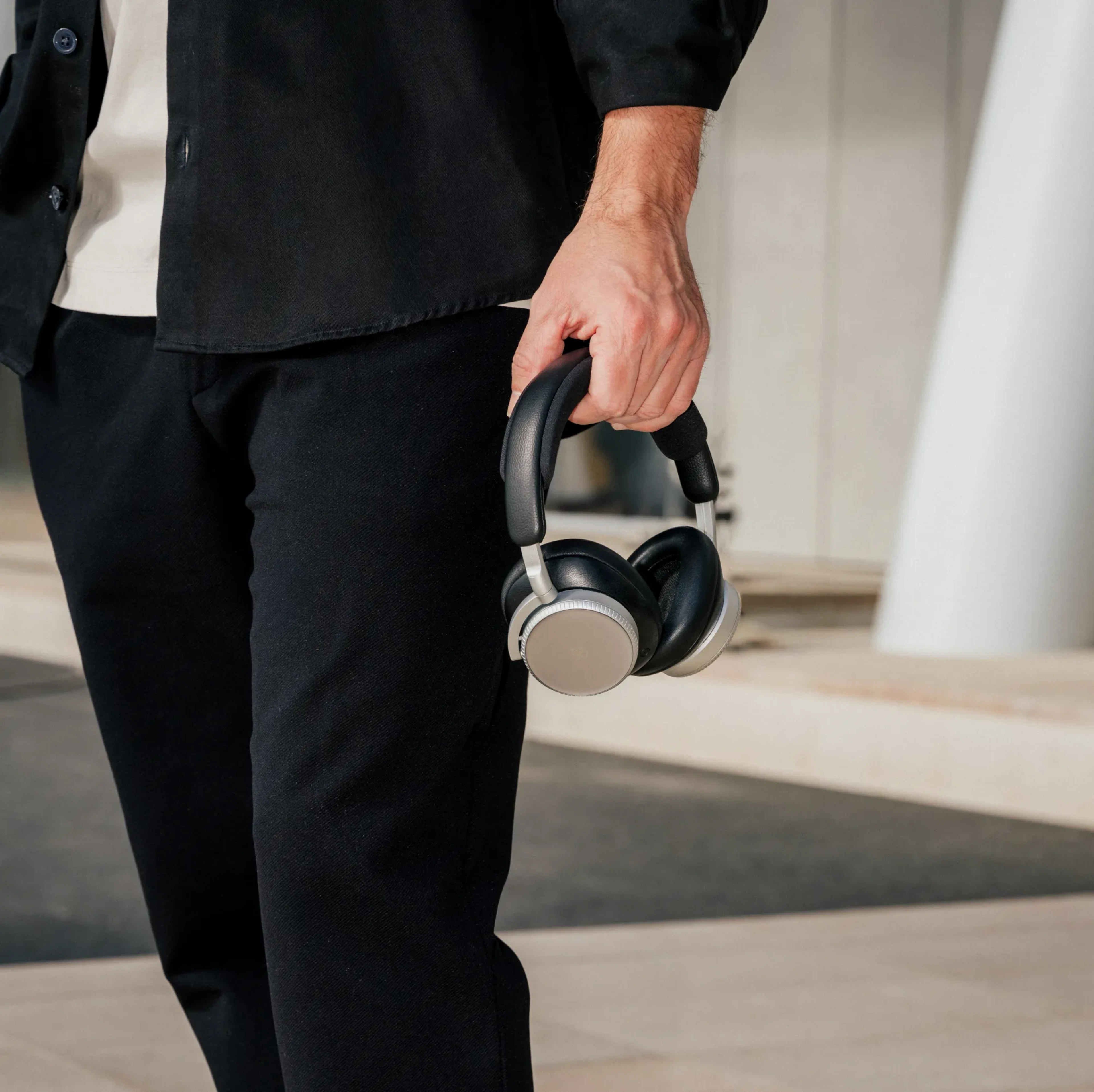 Fernando Alonso holding Bang & Olufsen Beoplay H100 headphones