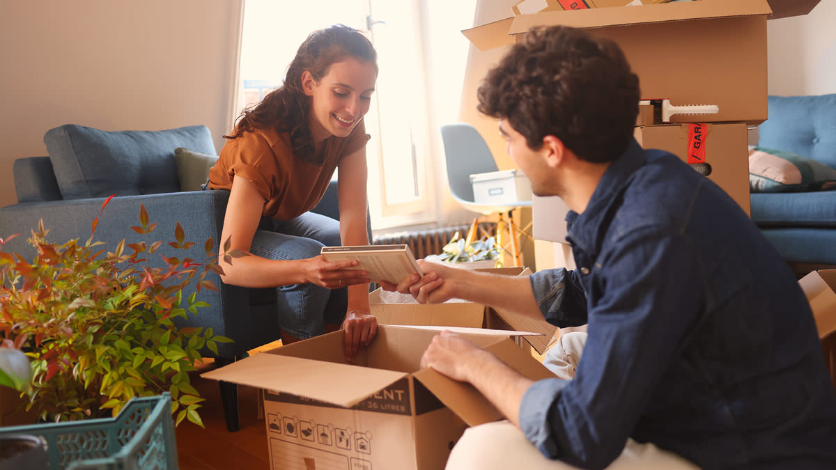 Man and woman unpacking boxes of books