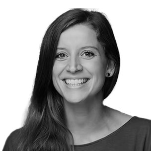 Black and white portrait of a smiling woman with shoulder-length hair, bright eyes, and a cheerful expression.