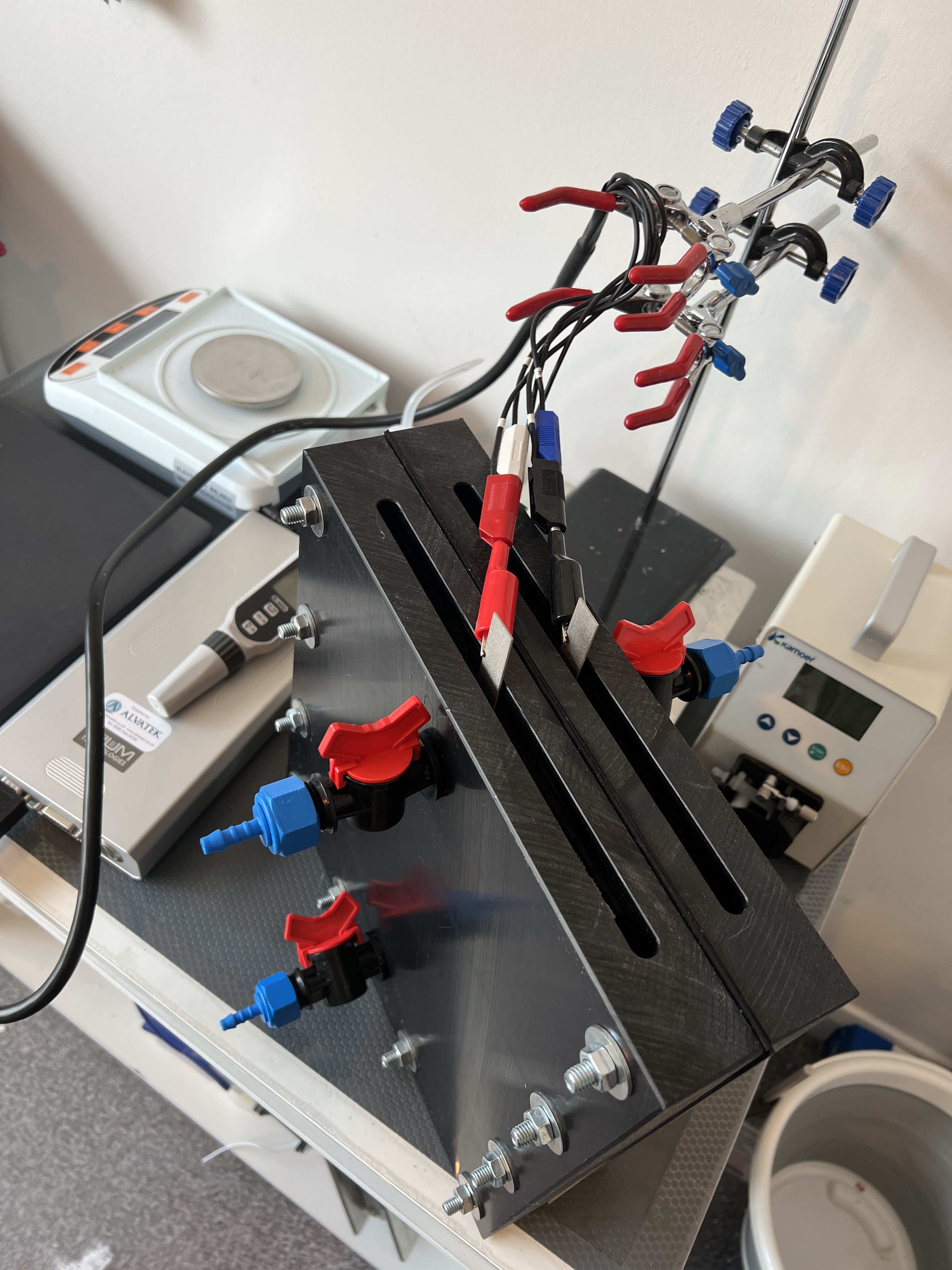 Laboratory setup with test tubes, clamps, and scientific instruments on a workbench for chemical or biological experiments.