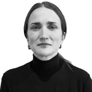 Black and white portrait of a woman with short dark hair wearing a black turtleneck, looking directly at the camera with a neutral expression.