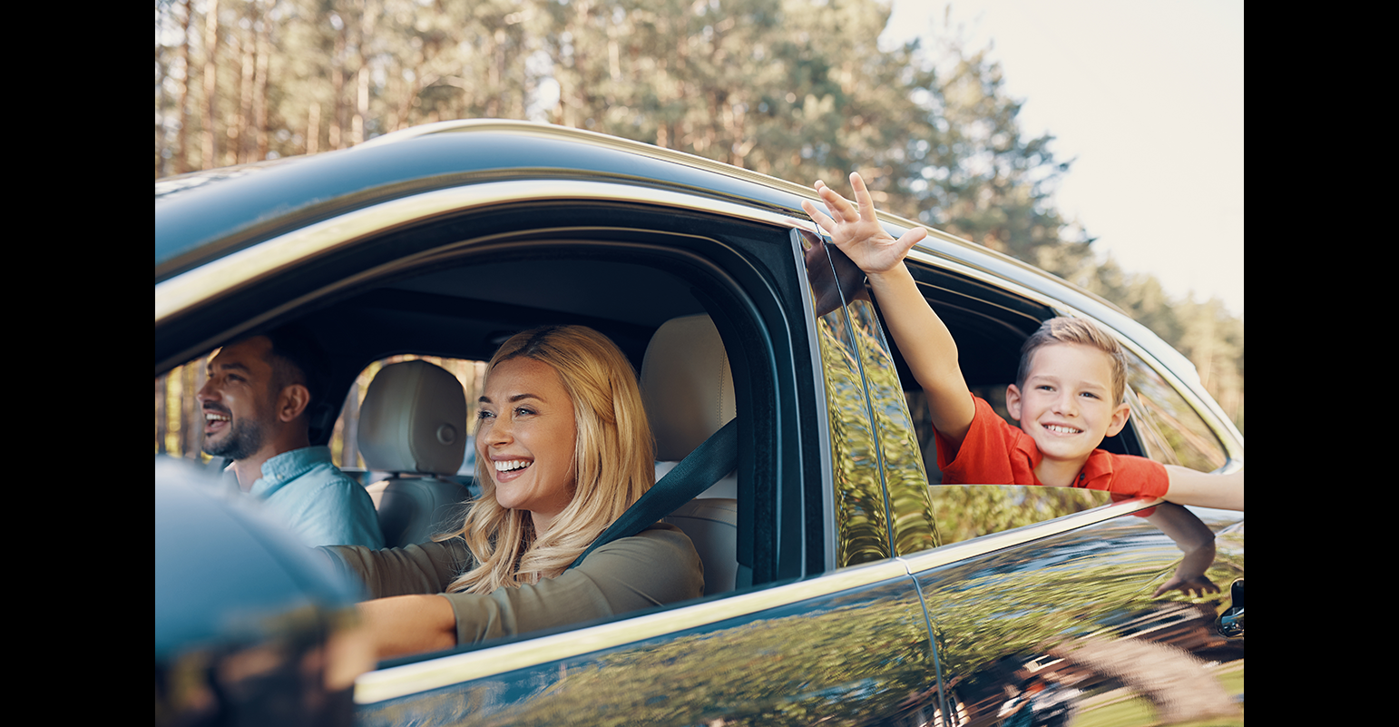 Image décorative : famille heureuse en voiture.