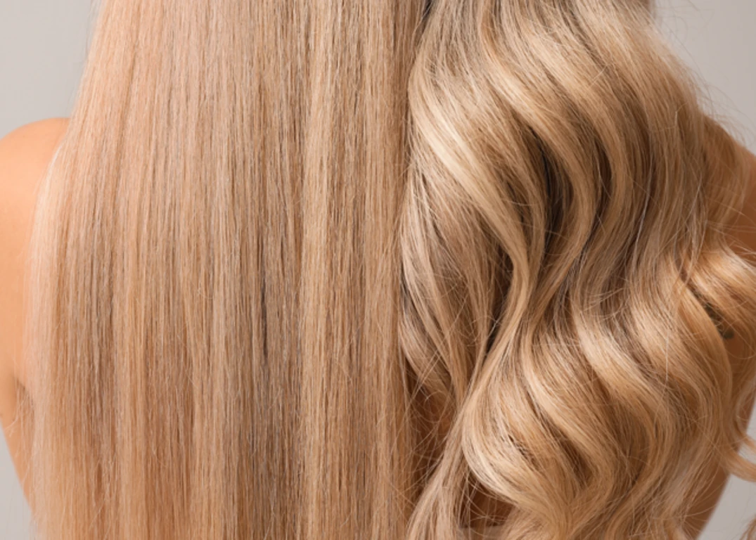 Women with fair skin and blonde hair has the left half of hair straight and the right half of hair wavy in front of a grey background