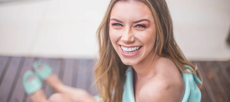 Smiling Caucasian woman with straight 2a blonde hair woman wearing sea foam green outfit