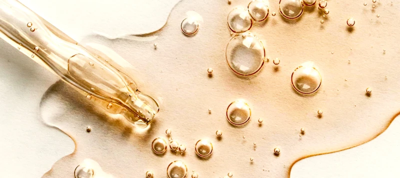 Gold hot oil is spread out on a white surface.