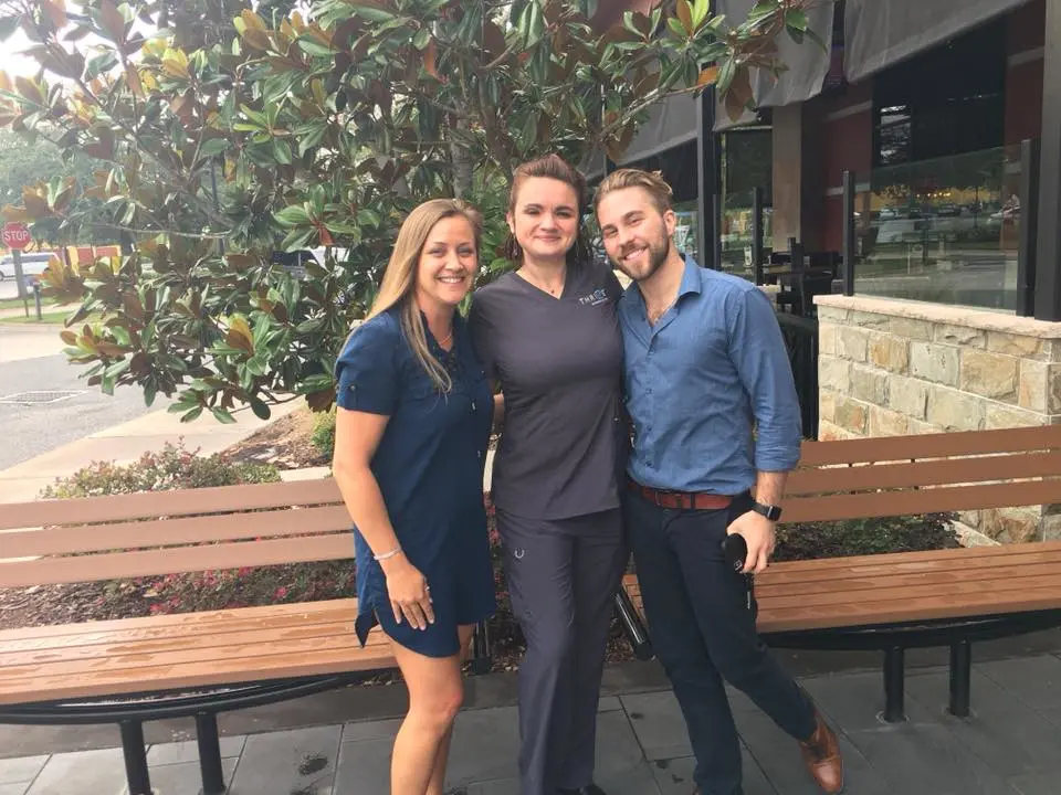 Katie and THRIVE team standing outside in front of bench