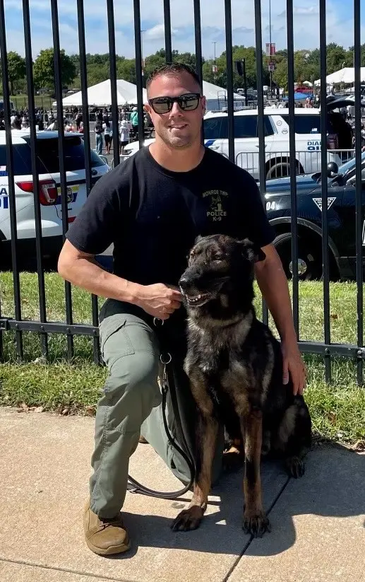 Officer Anthony D'Amico kneeling next to K-9 Rocky of the Monroe Township Police Department