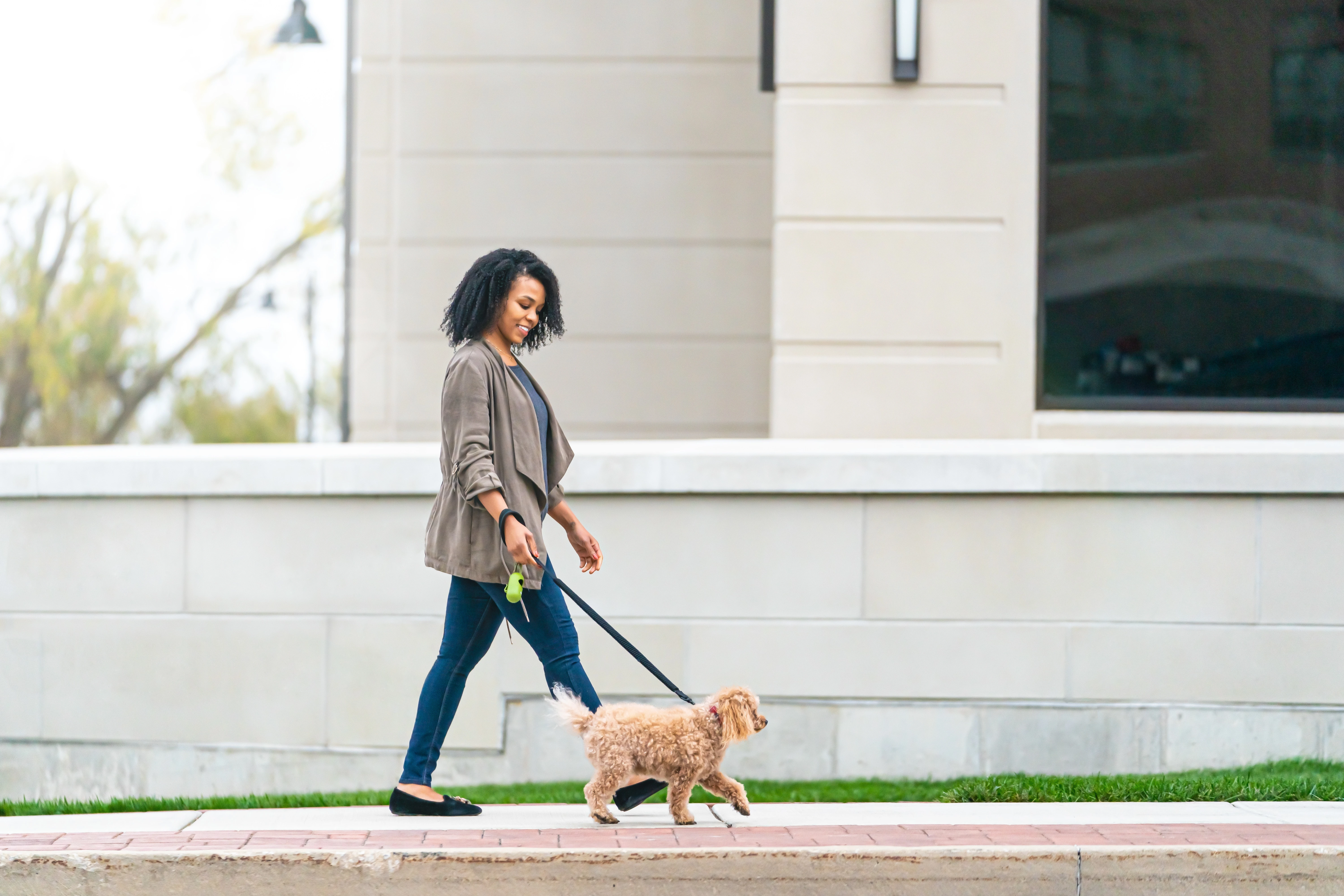 Woman walking dog on street
