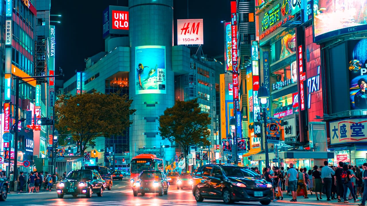  日本、人混みの多い夕方の街角のデジタルボード。