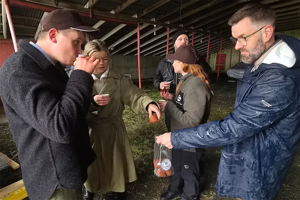 Trausti Jóhannsson, skógarvörður á Suðurlandi, gefur Jóhanni Páli Jóhannssyni ráðherra ástarpung með kaffinu í fjárhúsunum á Sogni eftir að fyrstu skóflustungurnar í átaki stjórnvalda í endurheimt votlendis höfðu verið teknar 2. október 2026.